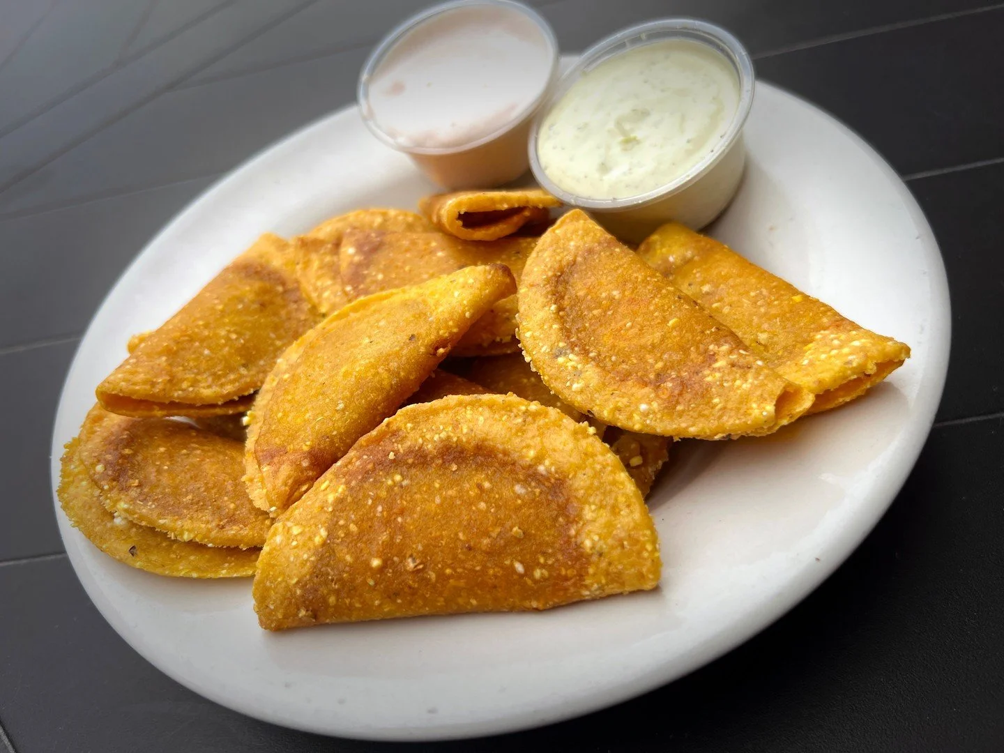 MINI TACOS: fried mini chicken tacos served with avocado ranch and jalape&ntilde;o-sriracha sour cream.