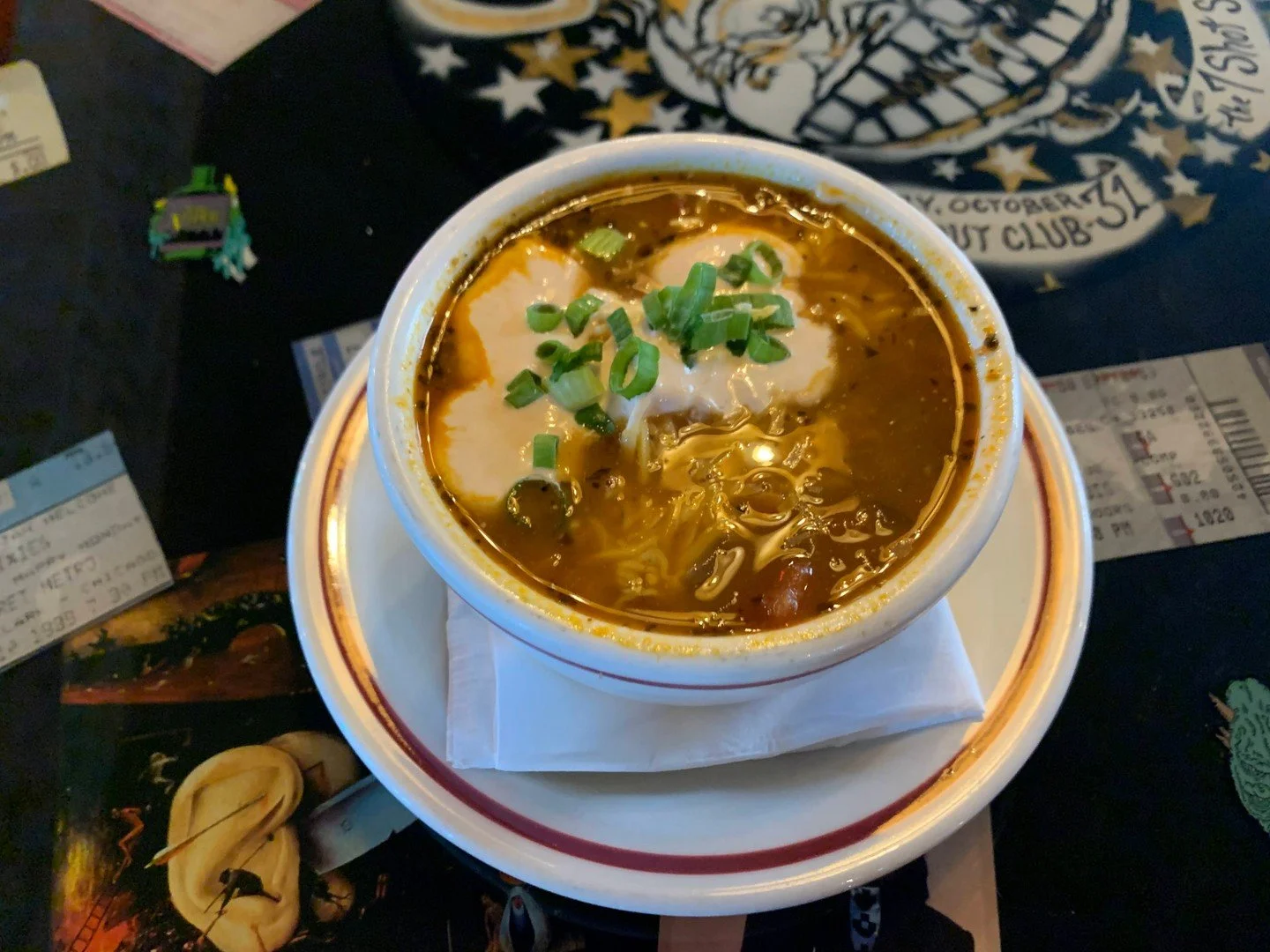 CHILI: Made from scratch red bean chili topped with melted cheddar, jalapeno-sriracha sour cream, and green onions. Get a cup or a bowl.