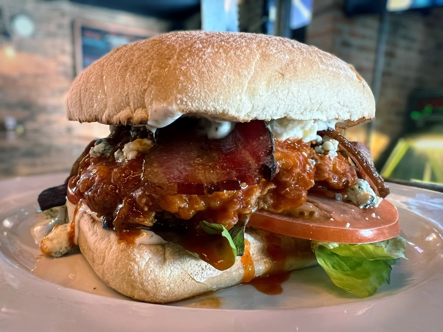 HOT HONEY CHICKEN! Fried chicken tossed in spicy honey sauce with mixed greens, tomato, Gorgonzola, bacon, and ranch on ciabatta.