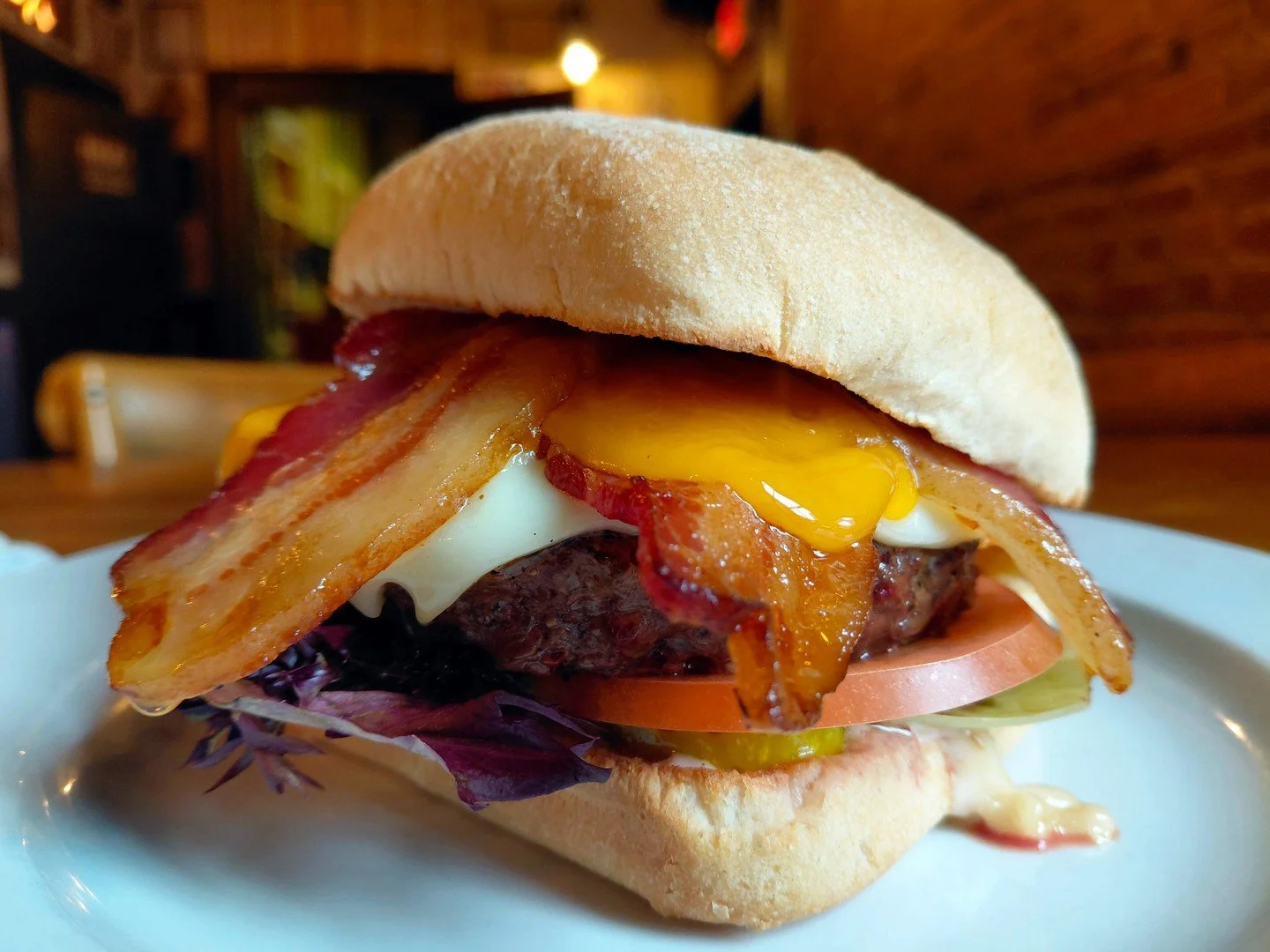 Eat Crow WEEKLY SPECIAL &bull;🥓 Big Bacon Burger 🍔: Half-pound burger patty on a ciabatta bun, with garlic mayo, pickles, mixed greens, tomato slices, Swiss and cheddar cheese, and 4 strips of bacon - $20, comes with a choice of side. Available Feb