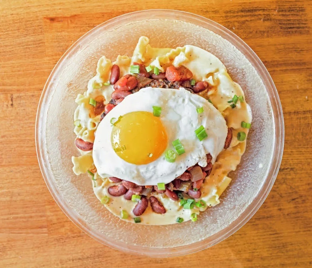 SLINGER MAC: Our original mac &amp; cheese with a half-pound beef patty covered in veggie chili, topped with a sunny side up egg, and garnished with green onions