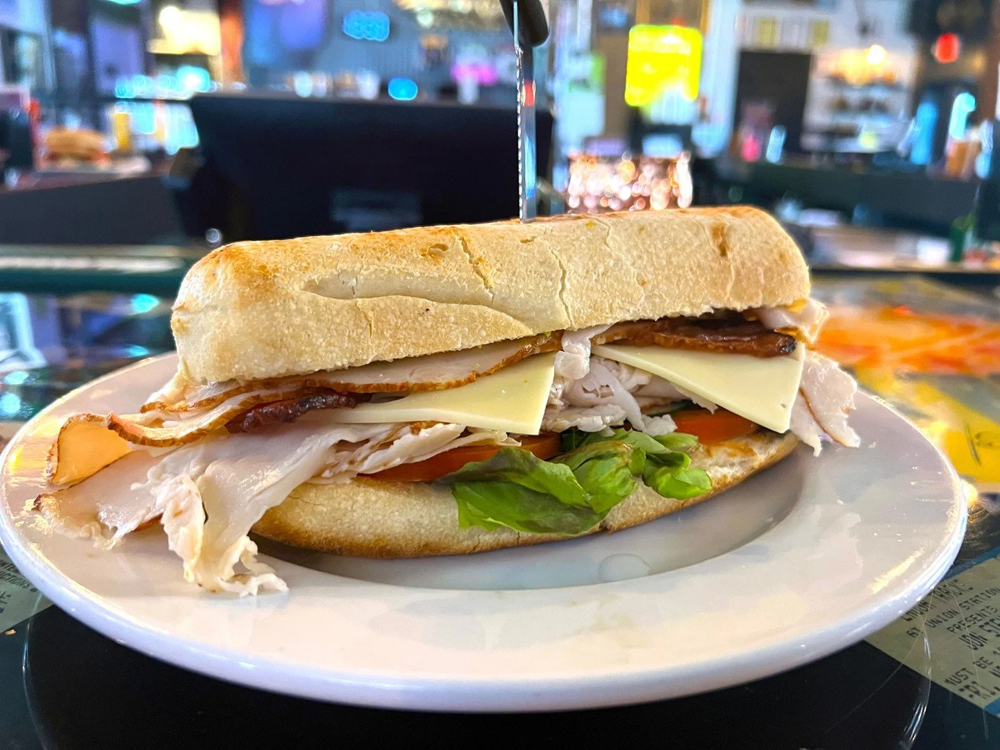 BEACH CLUB: house-cut turkey breast, bacon, Swiss cheese, avocado, cucumber, tomato, mixed greens, and deep-fried garlic mayo on a hoagie bun. Comes with a choice of side.
