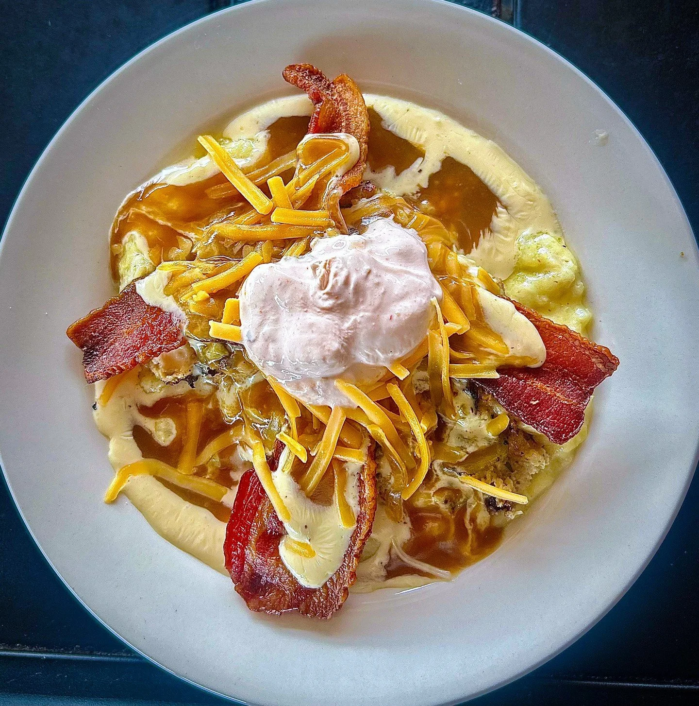 KITCHEN SINK: a bed of caraway smashed potatoes topped with a turkey burger, loaded with green chile, gouda jalape&ntilde;o cheese sauce, gravy, cheddar cheese, bacon, and sriracha sour cream.

#EatCrowSTL #KitchenSink #ComfortFood #TurkeyBurger #Loa