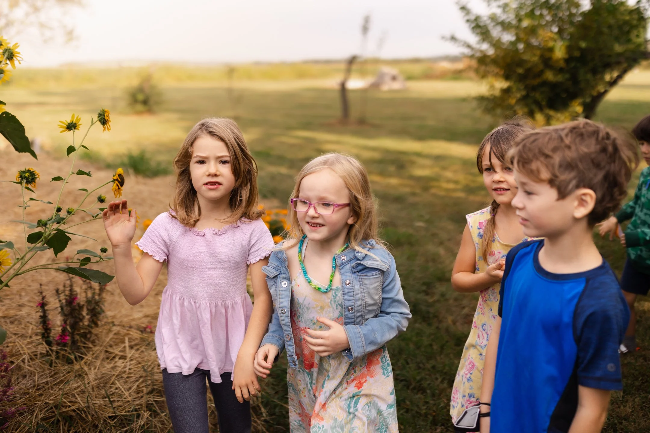 Four 1st graders are in movement outdoors as they walk in a garden at the Prairie Moon Waldorf School. A holistic education for the whole child