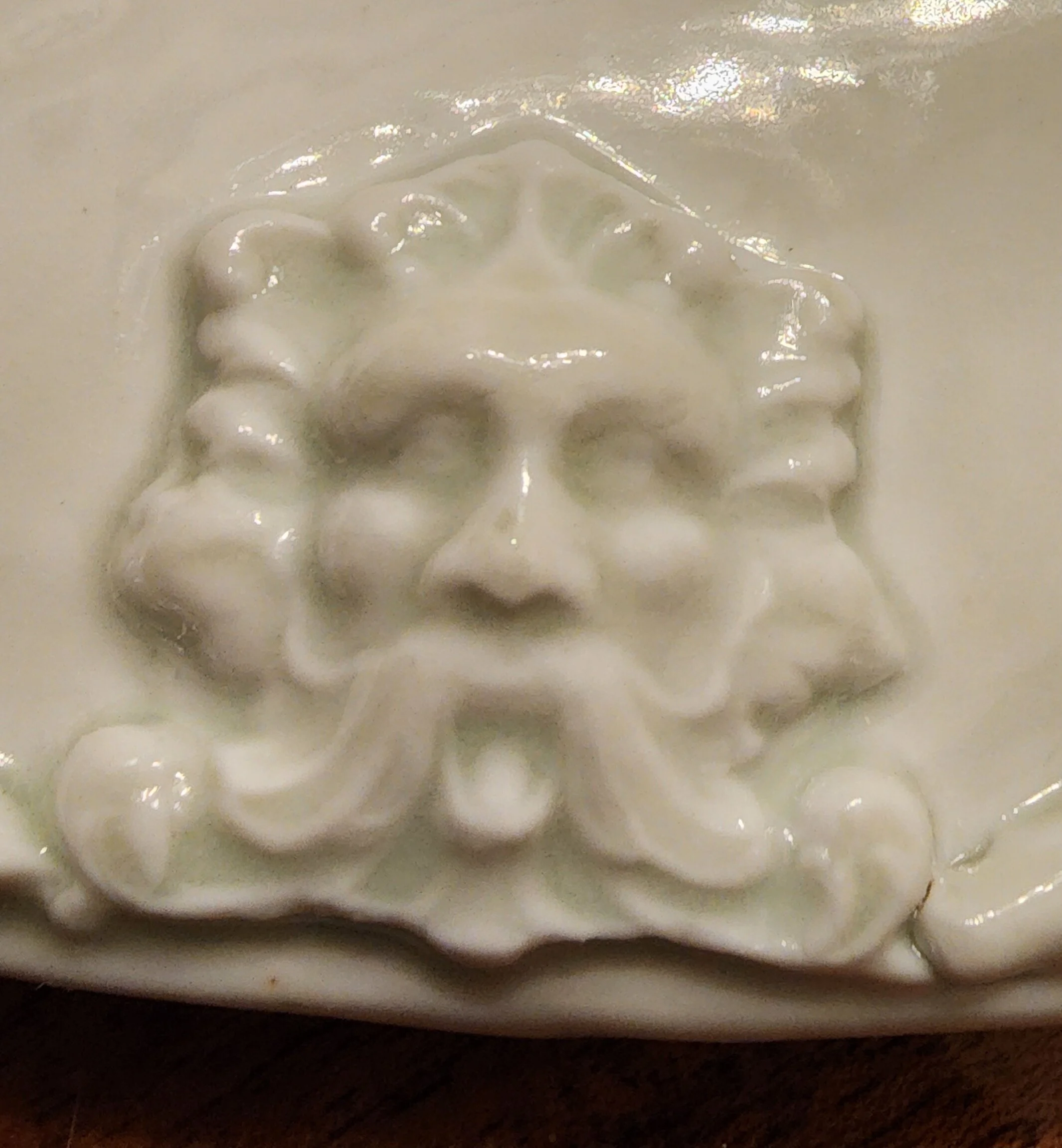 Ceramic plate detail with embossed Greenman Face