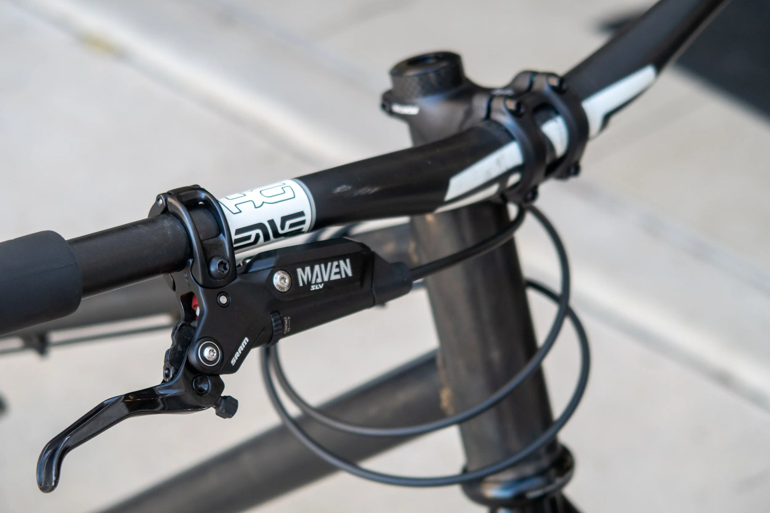 Close-up of a black mountain bike handlebar with a SRAM MAVEN SLV gear shifter and brake lever.
