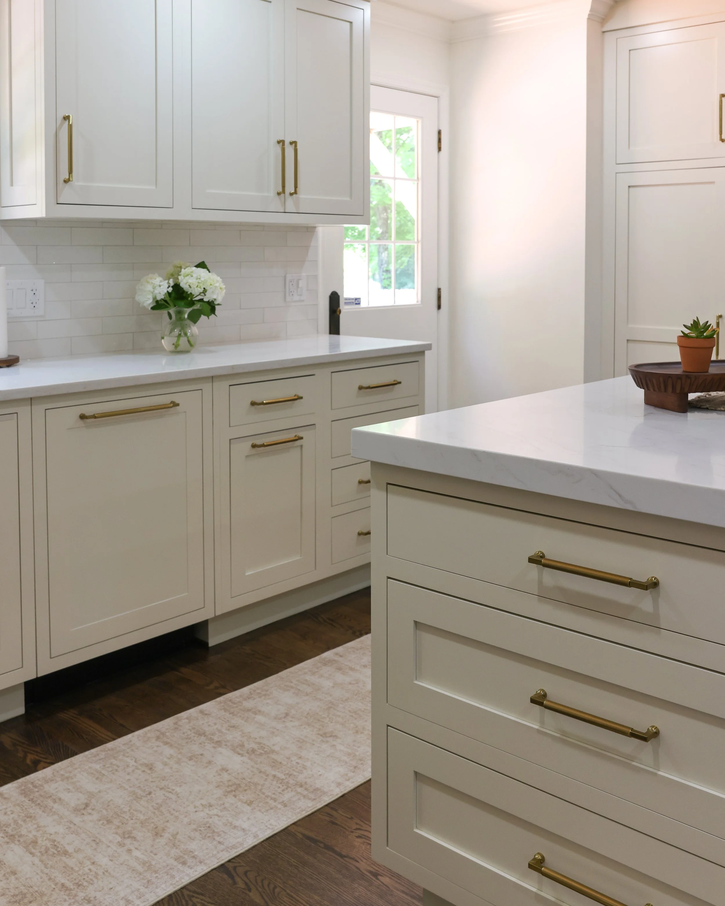 the back corner of a kitchen with white cabinets
