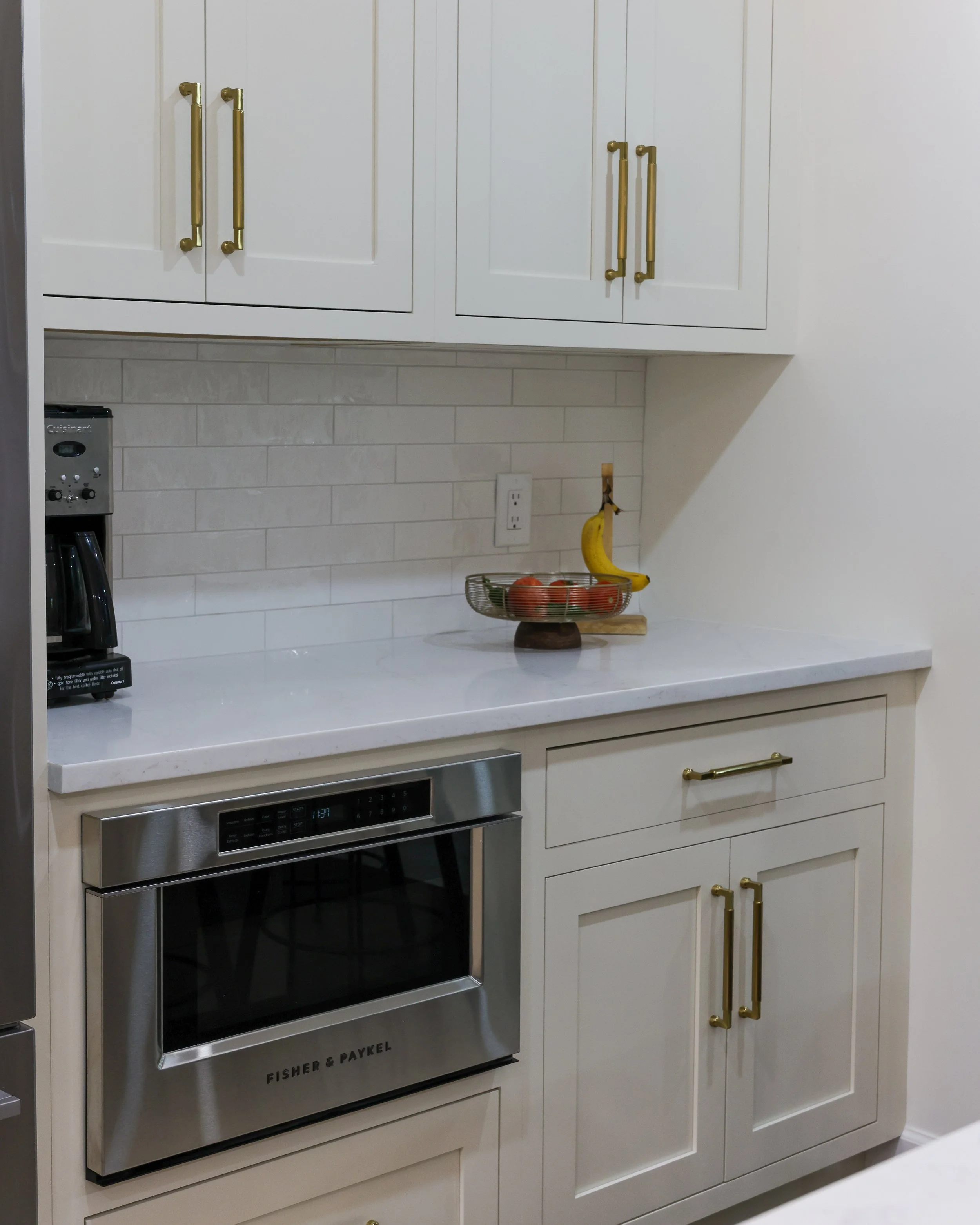 a built in microwave surrounded by white cabinets