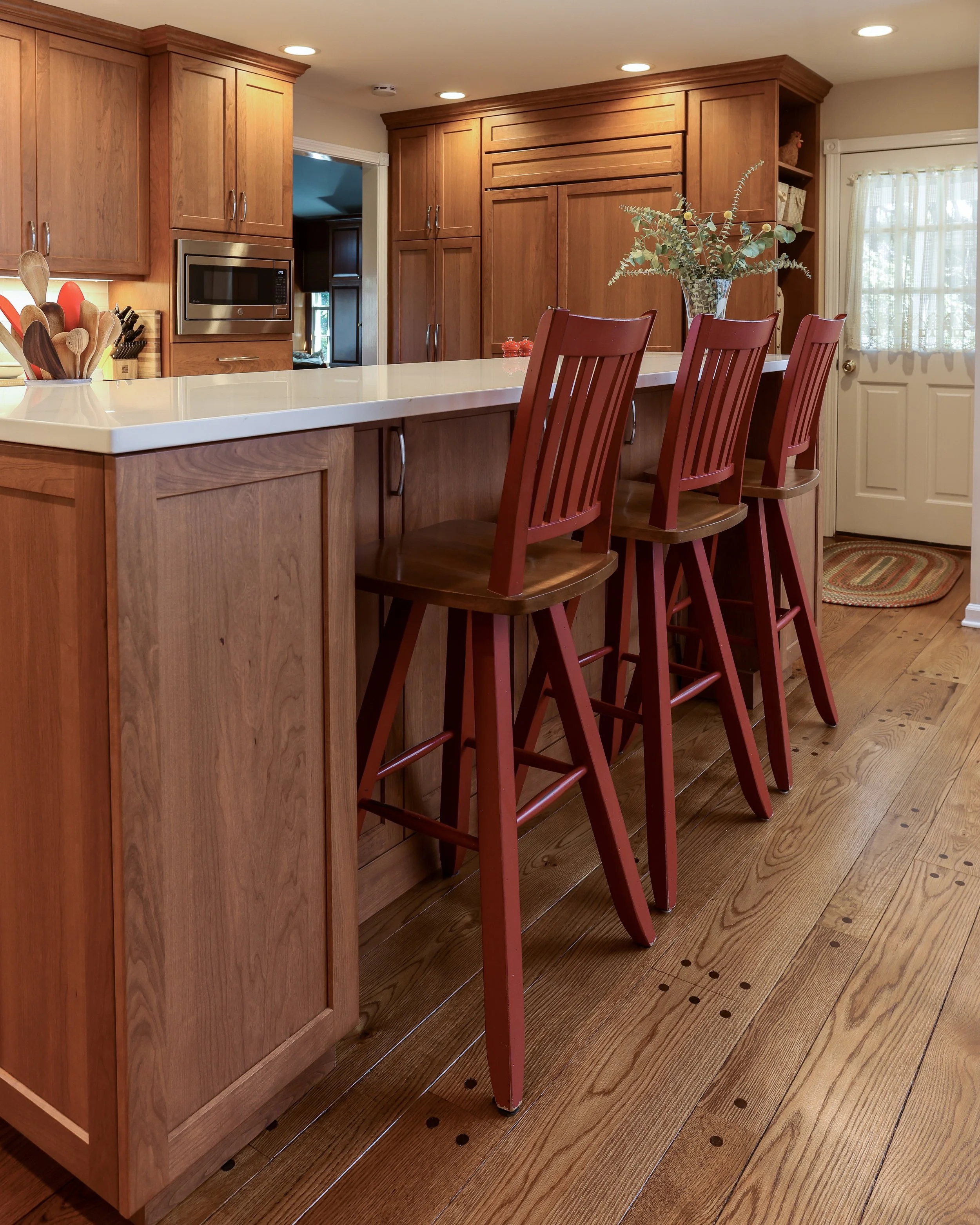 three red wood counter stools at the kitchen island