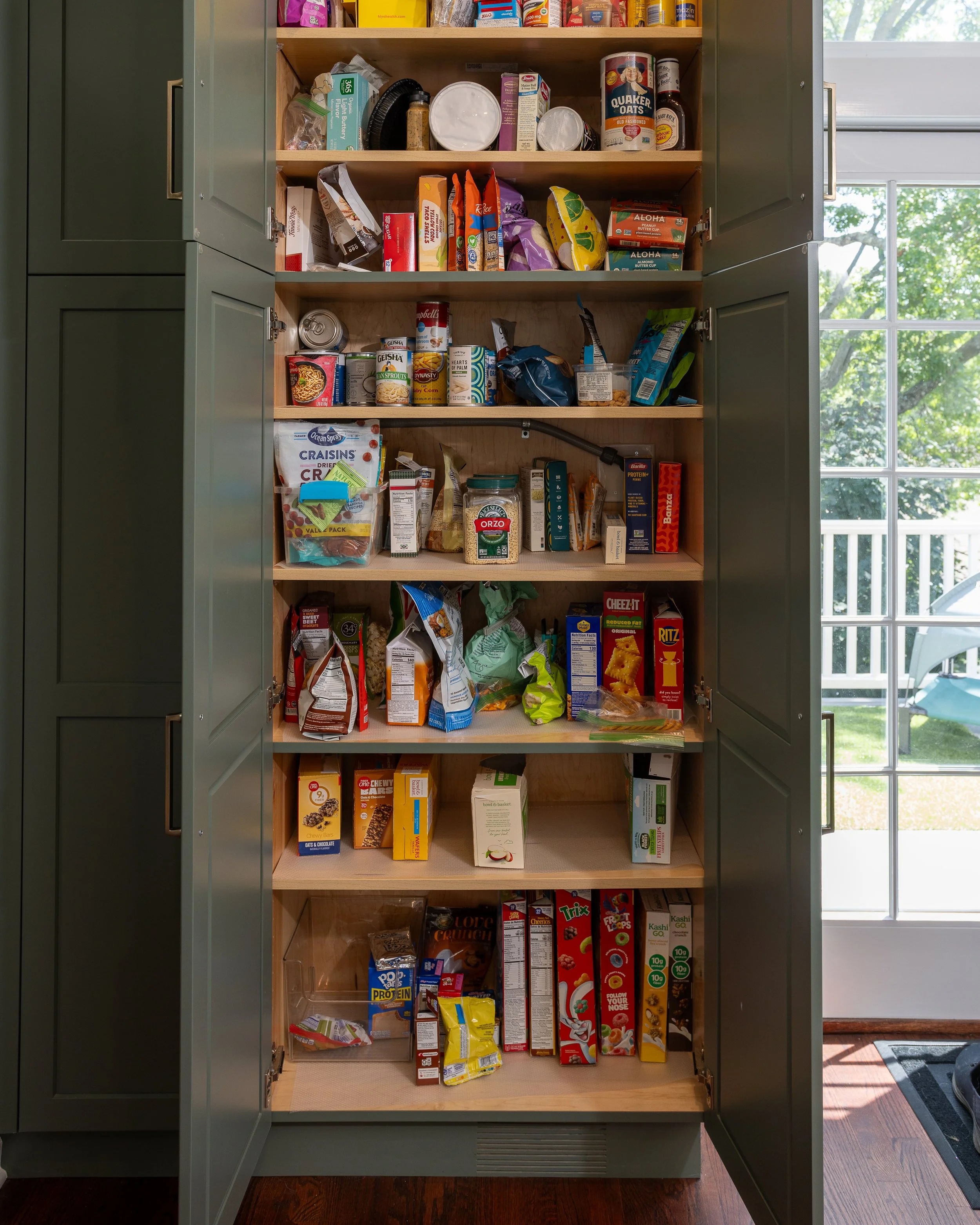 a built in pantry with the doors open