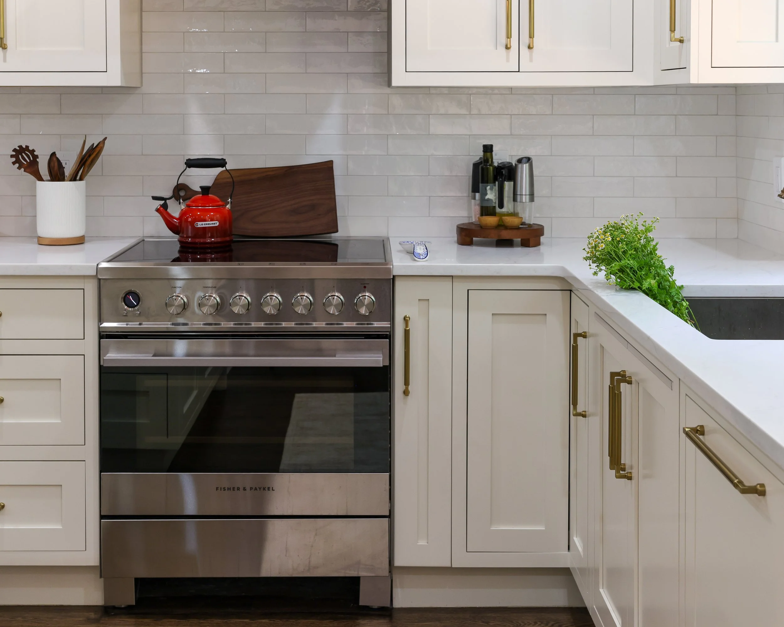 a stainless range surrounded by white cabinets