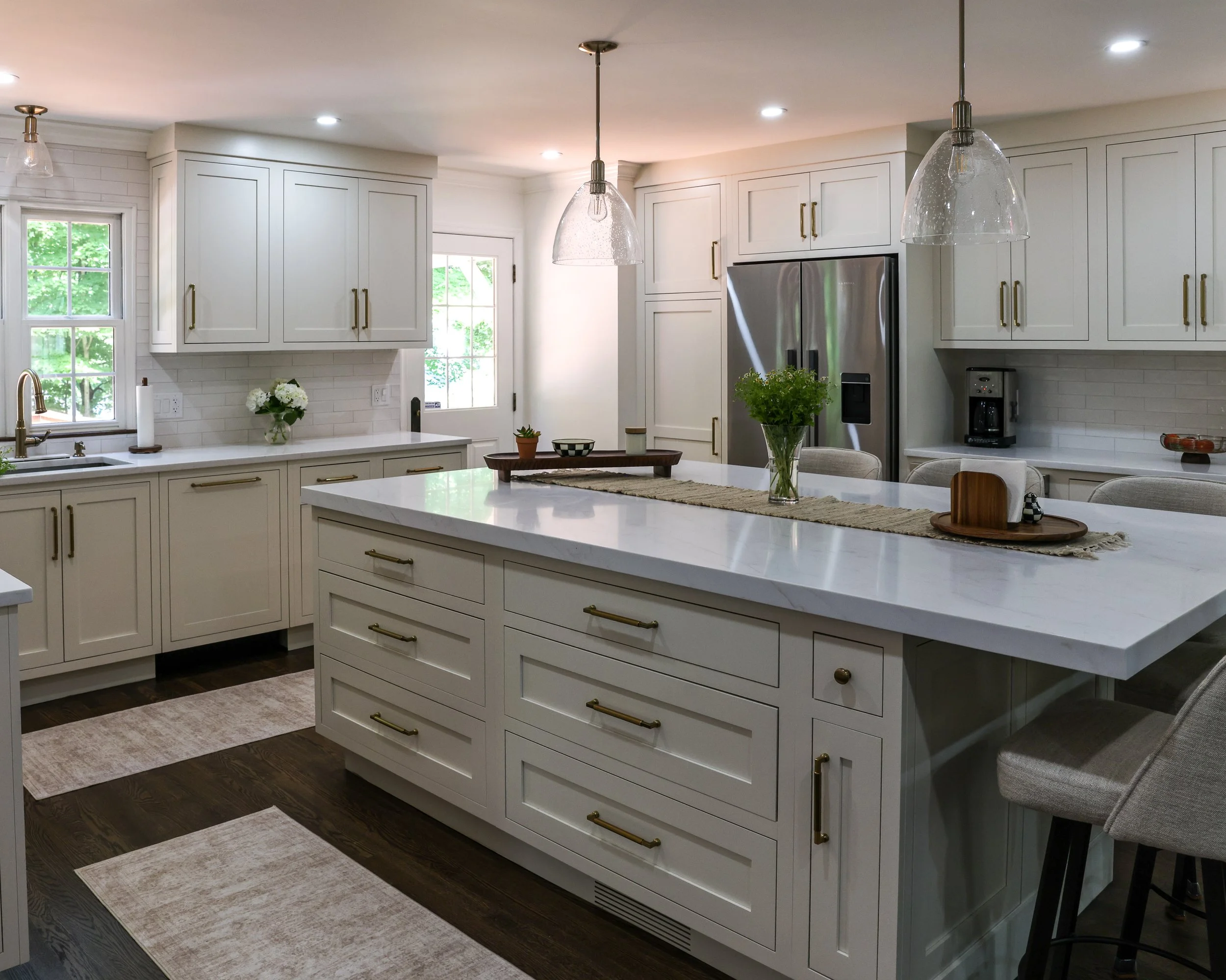 a kitchen with white cabinets, a large island, and stainless appliances
