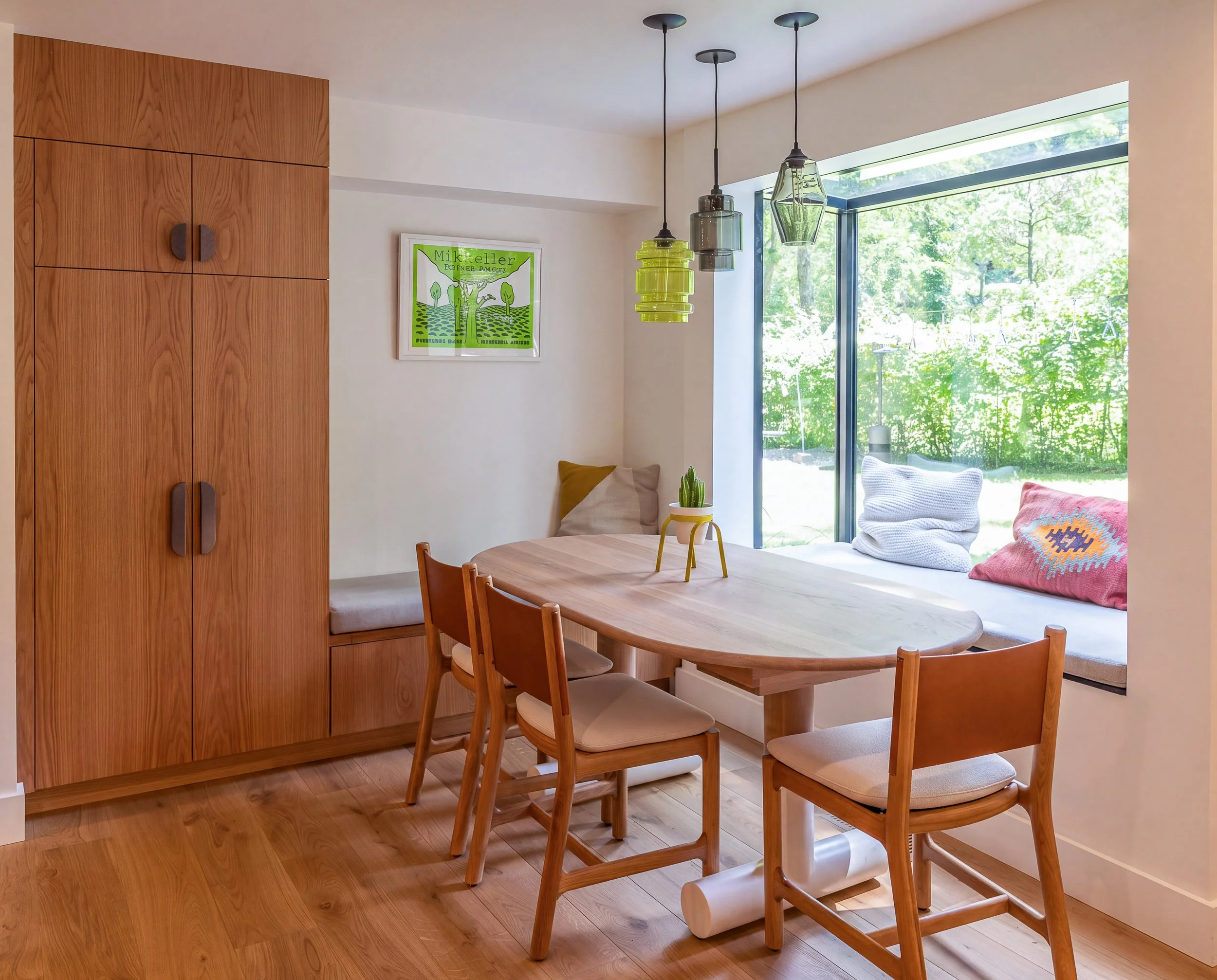a corner of a kitchen with a table and chairs and built-in cabinetry