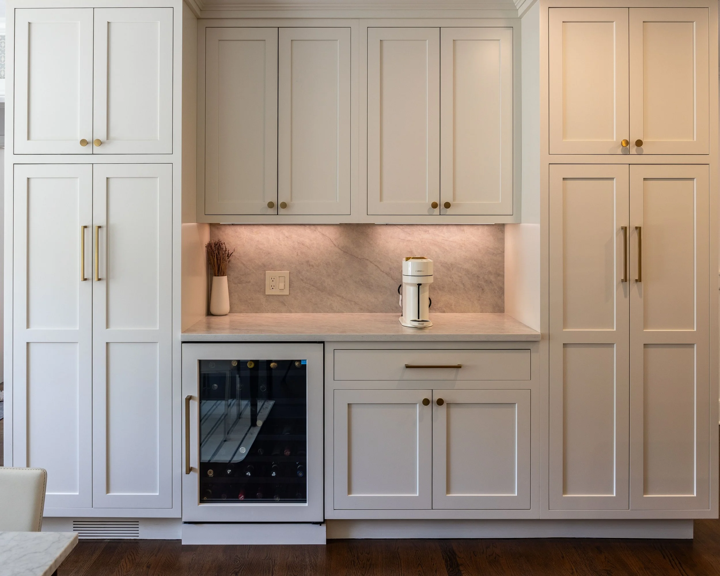 a large built in section of cabinets with a built in wine fridge