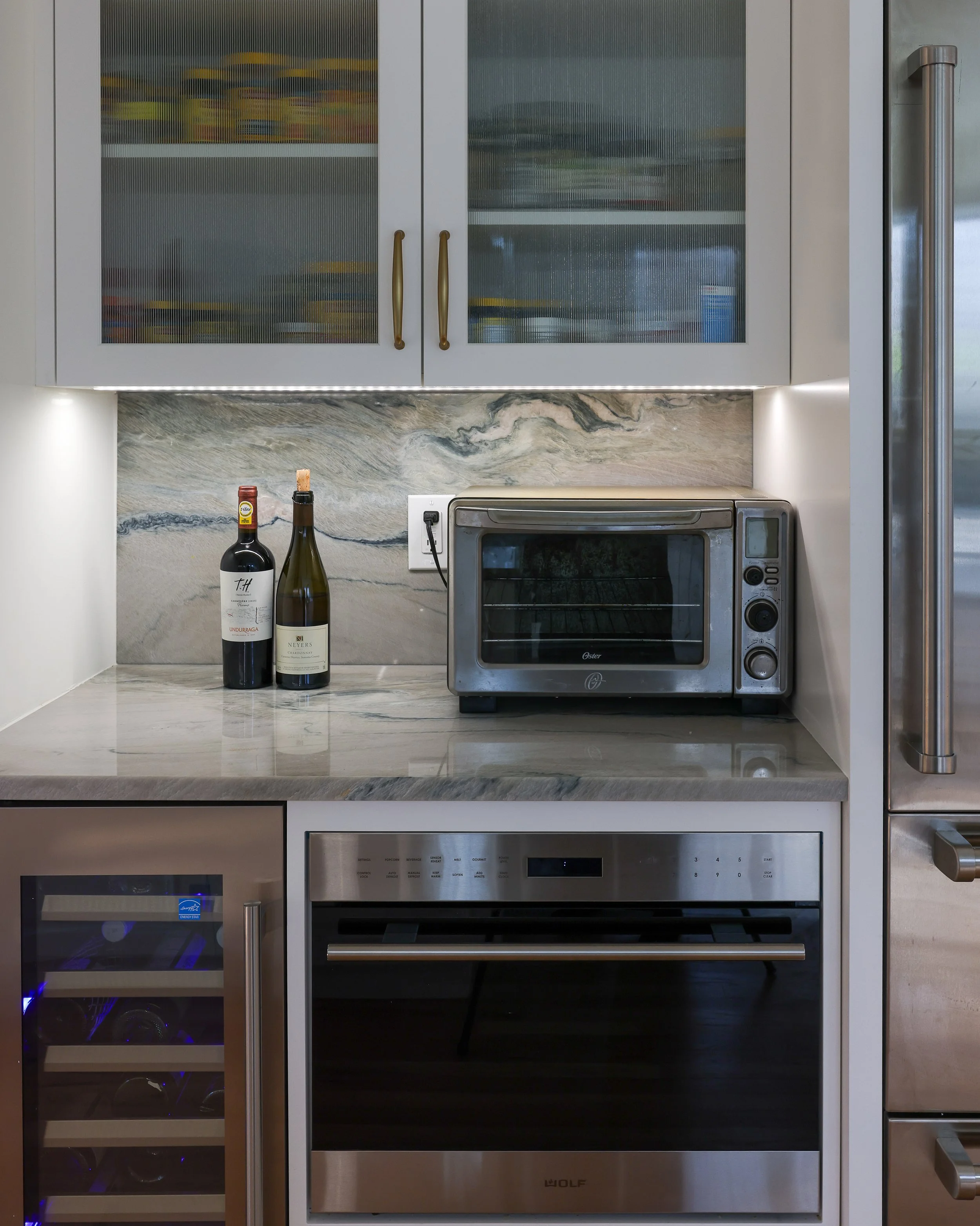 close up of a toaster and built-in oven and wine fridge.