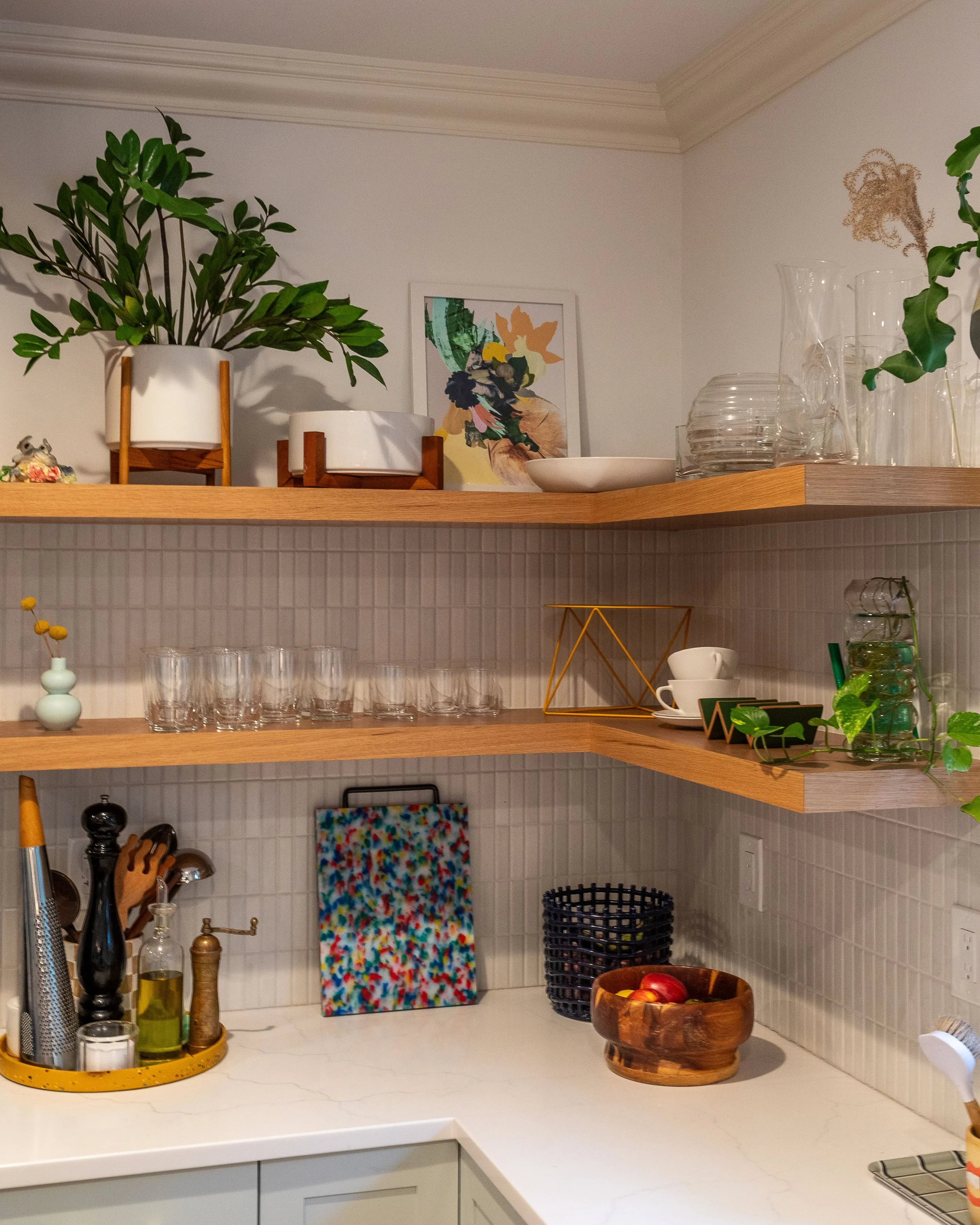 close up of floating shelves in a light wood color with glassware and plants on them