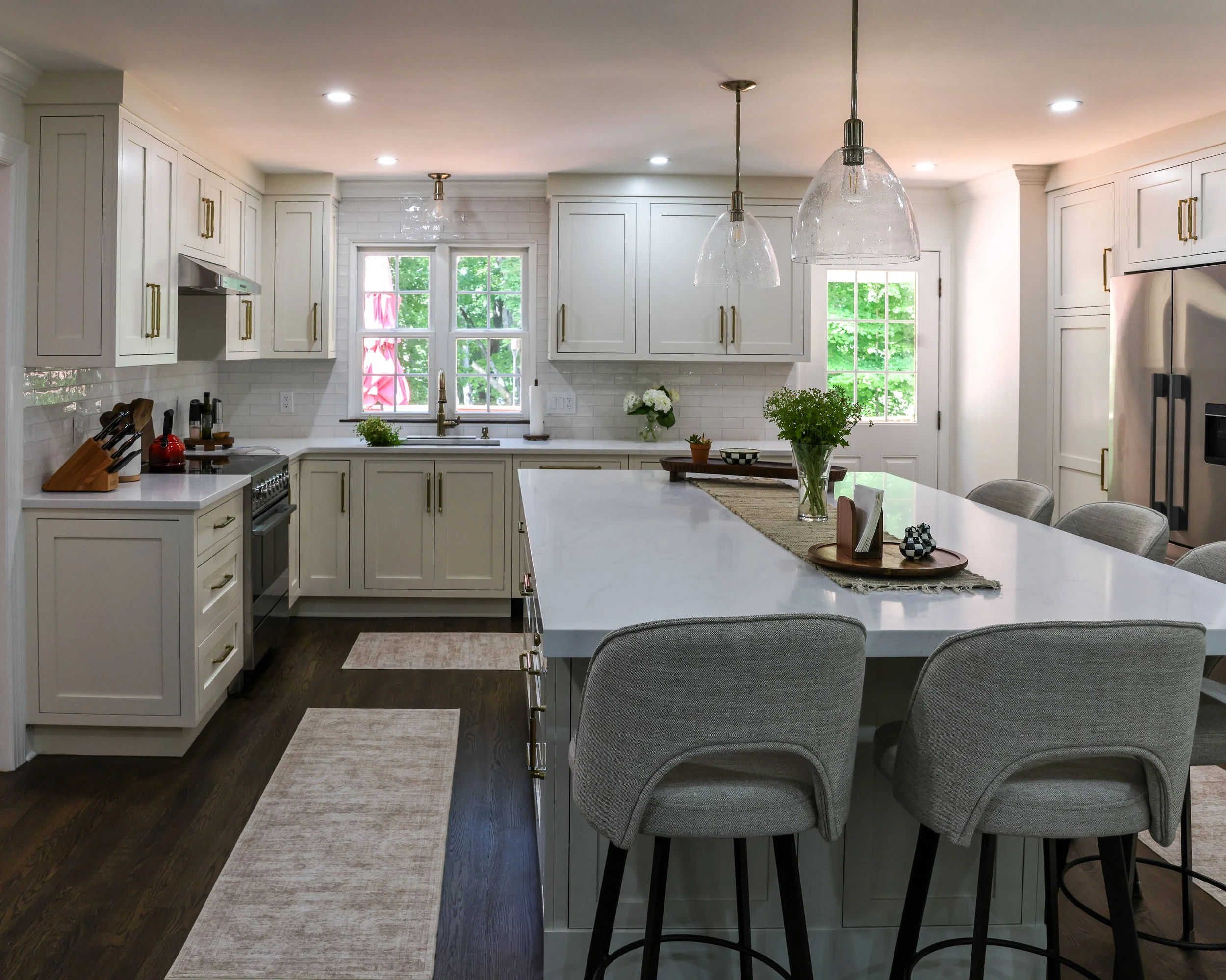 A kitchen with white cabinets and a large center island