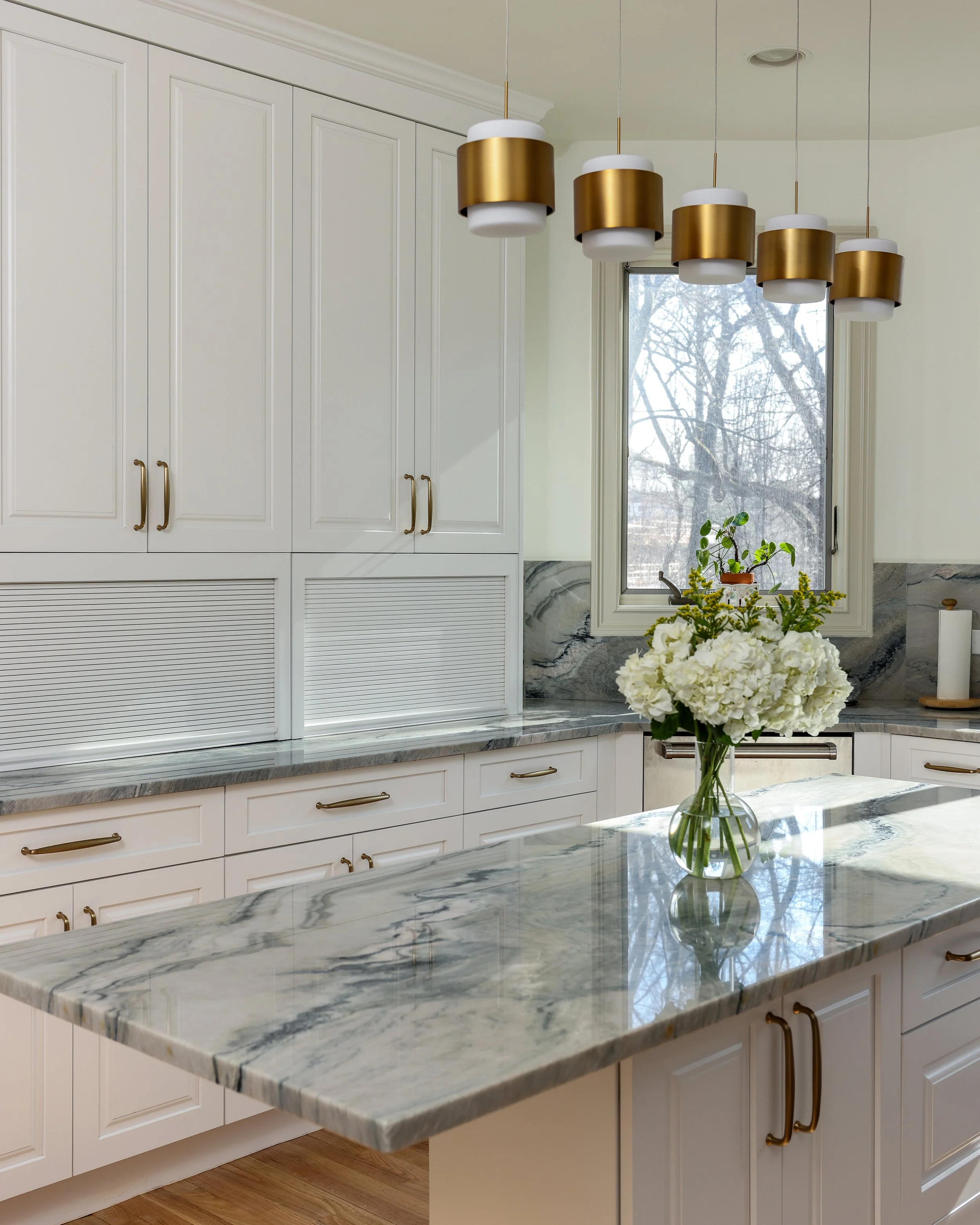 a kitchen with white cabinets and grey countertops
