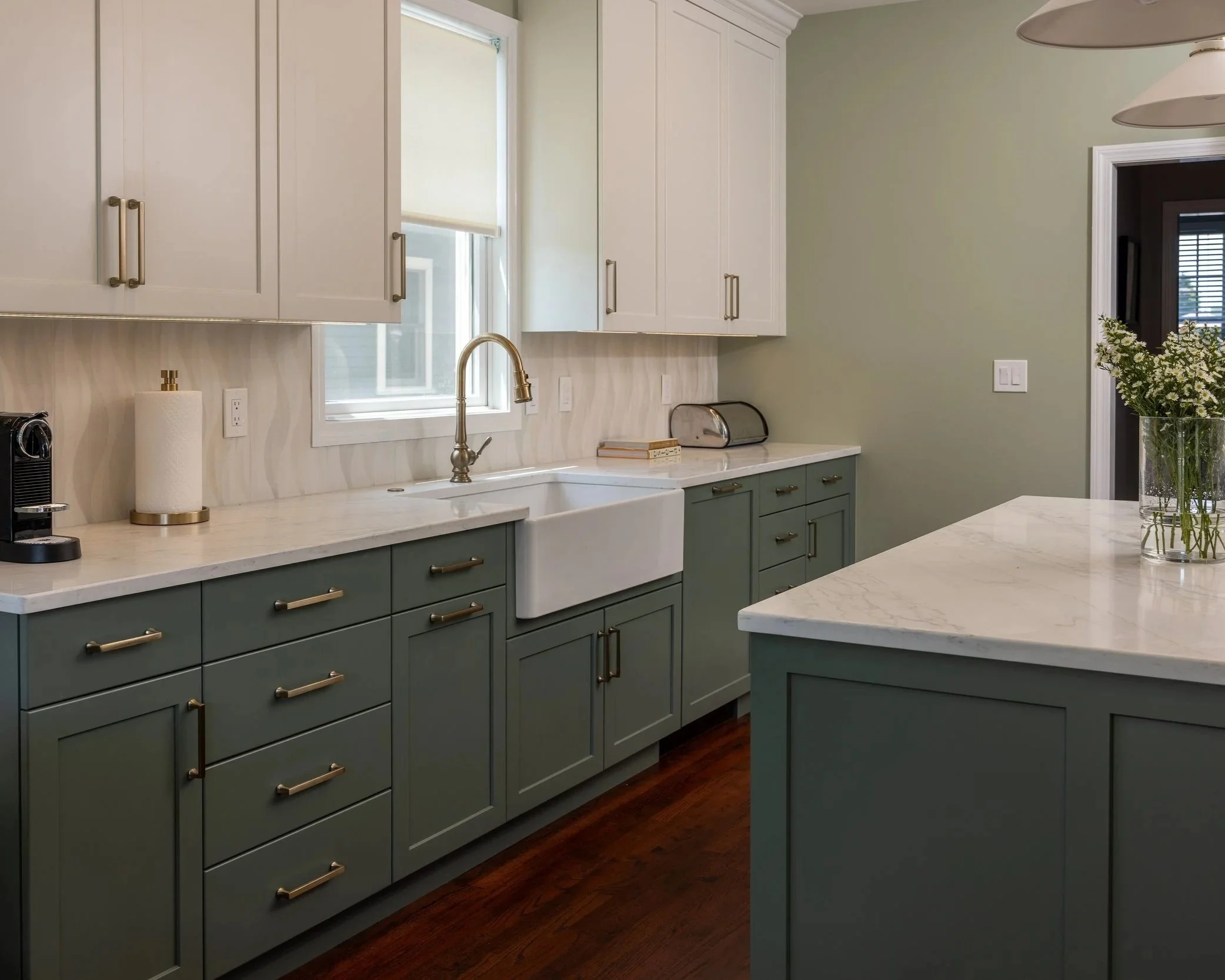 one side of a kitchen featuring a farmhouse sink with a window behind it.