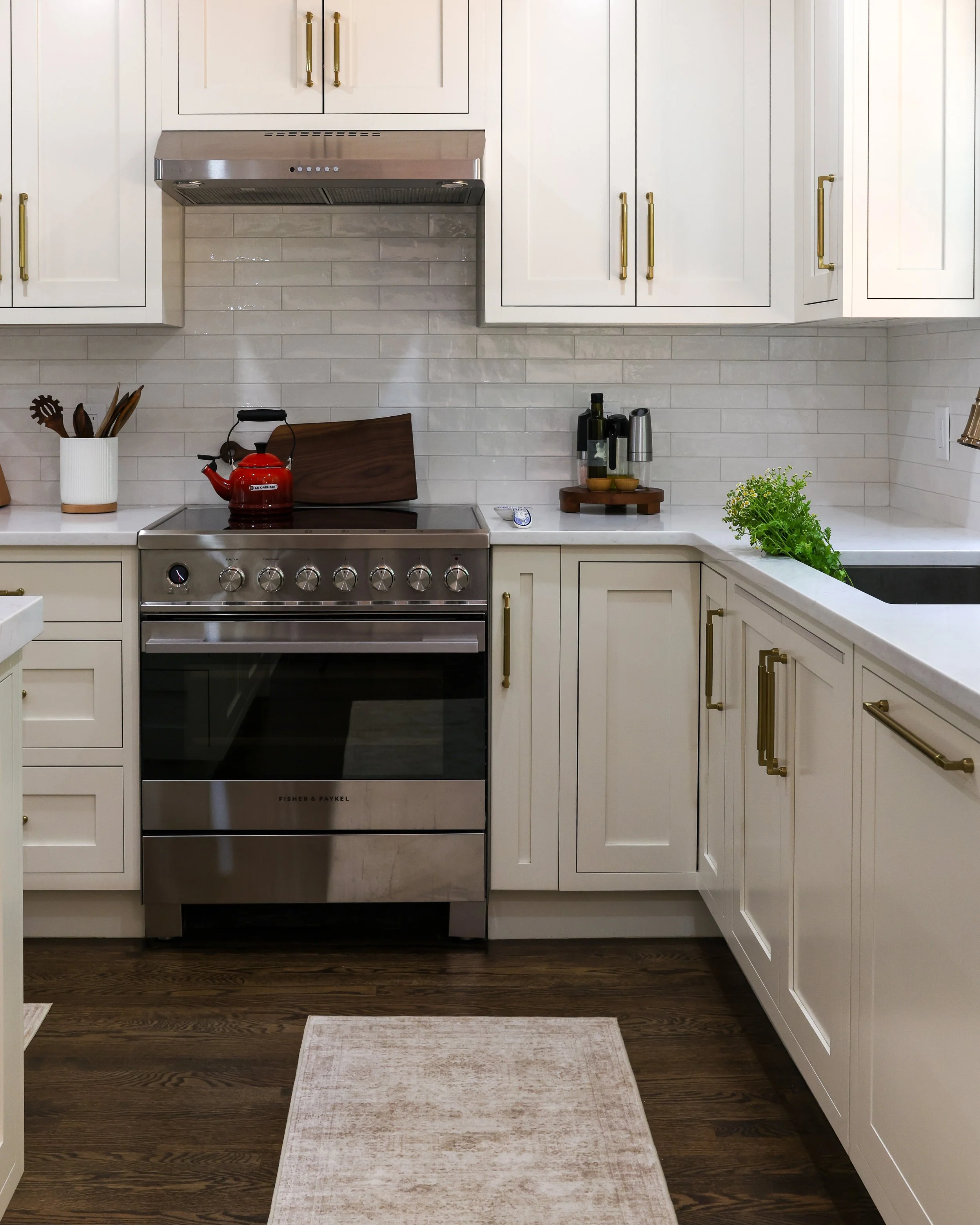 a stainless range surrounded by white cabinets