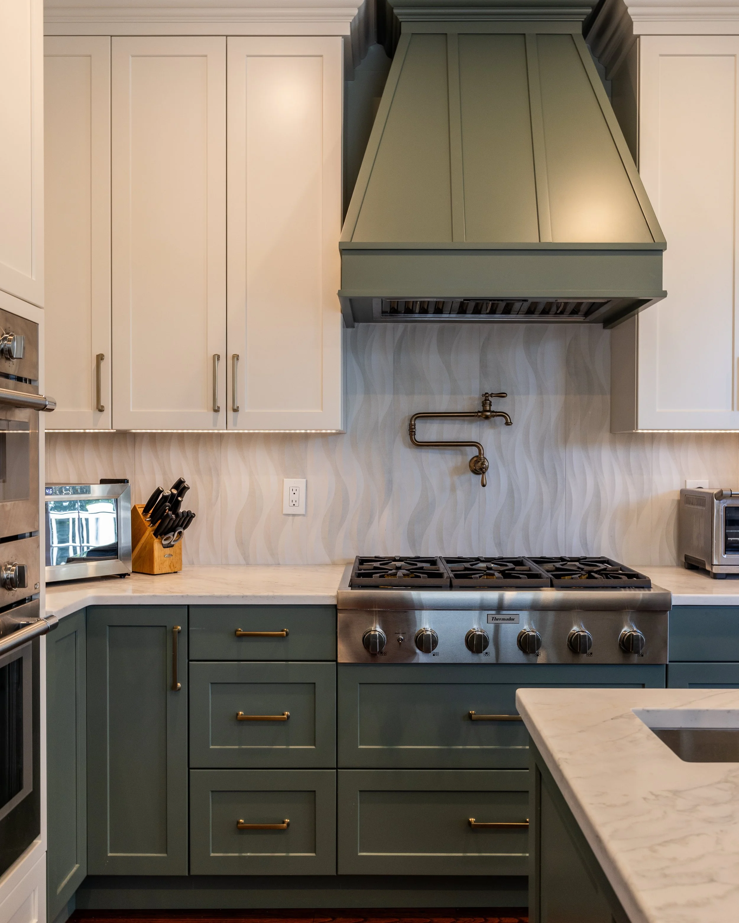 green base cabinets with a matching hood and white upper cabinets