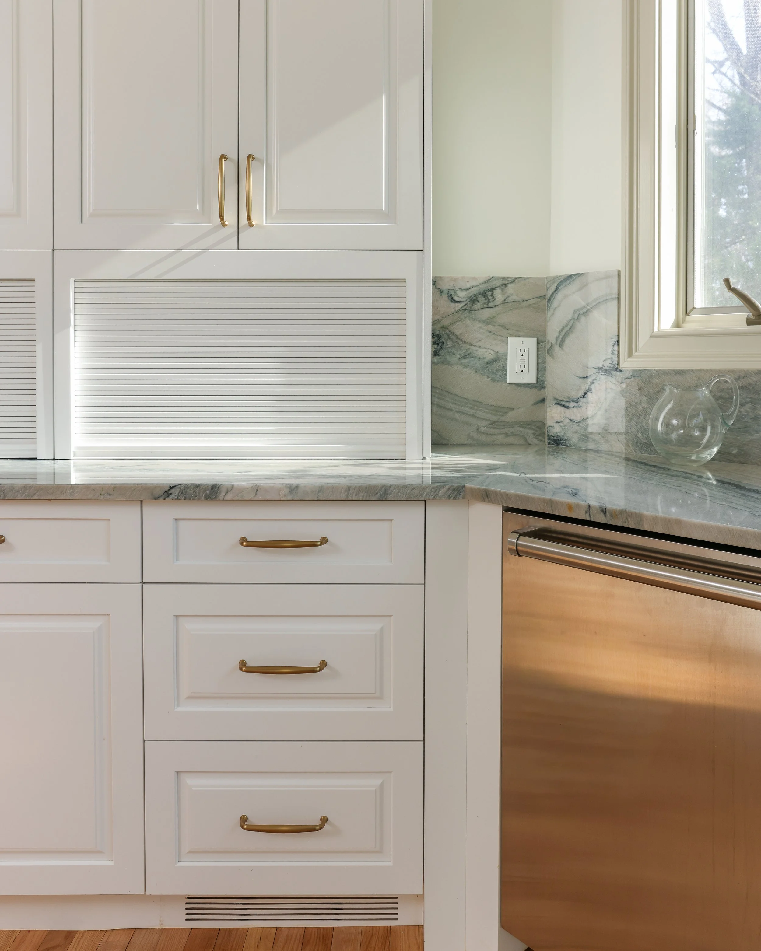 a close up on white cabinets with golden hardware