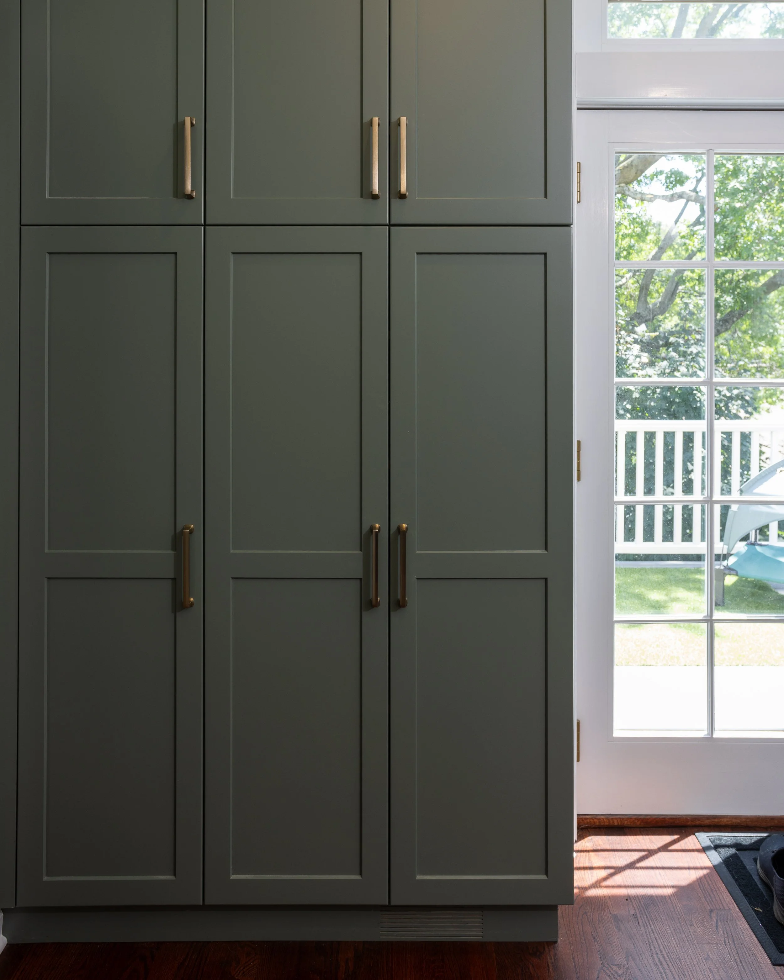 a built in pantry with green doors