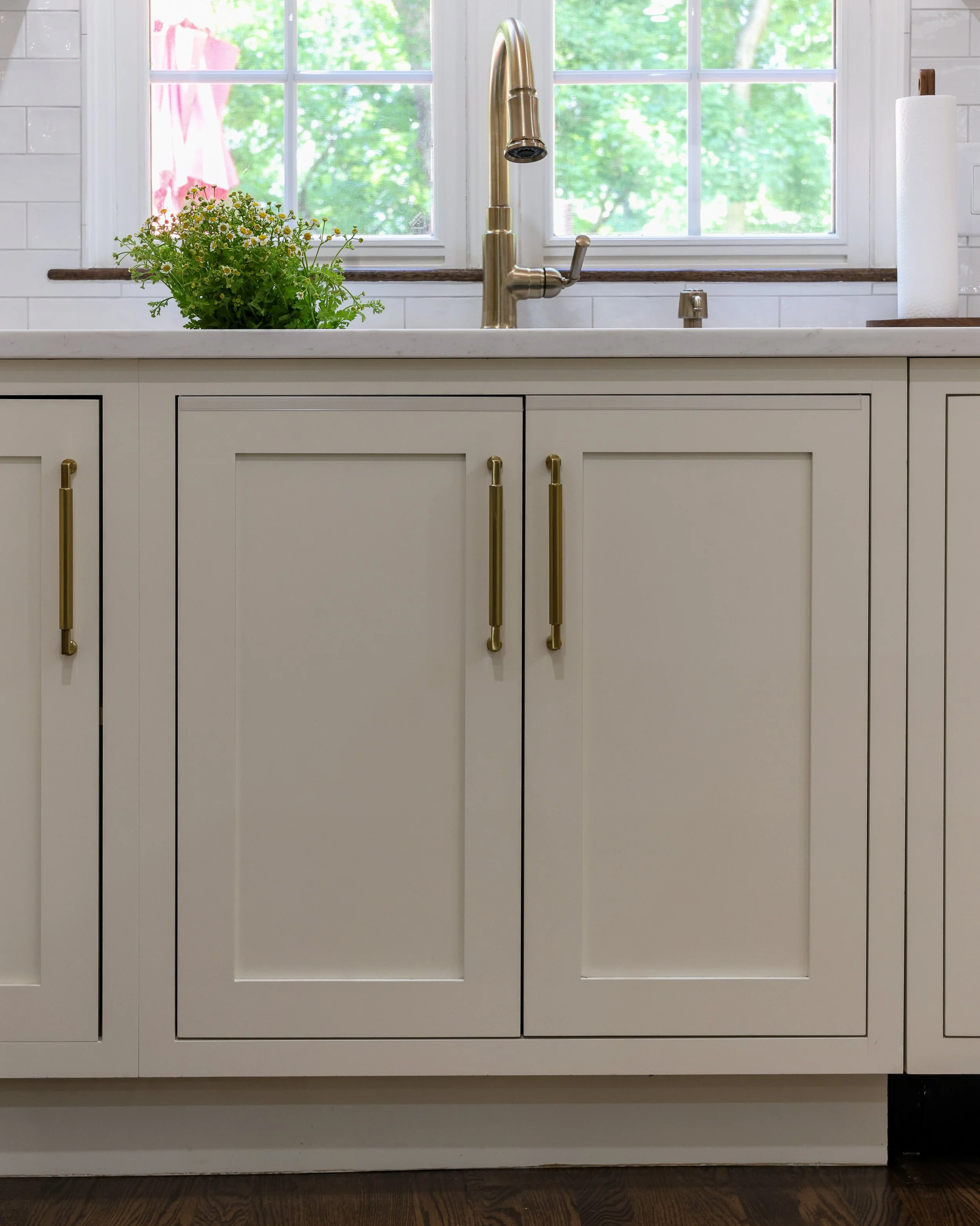 a sink in a kitchen with white cabinets