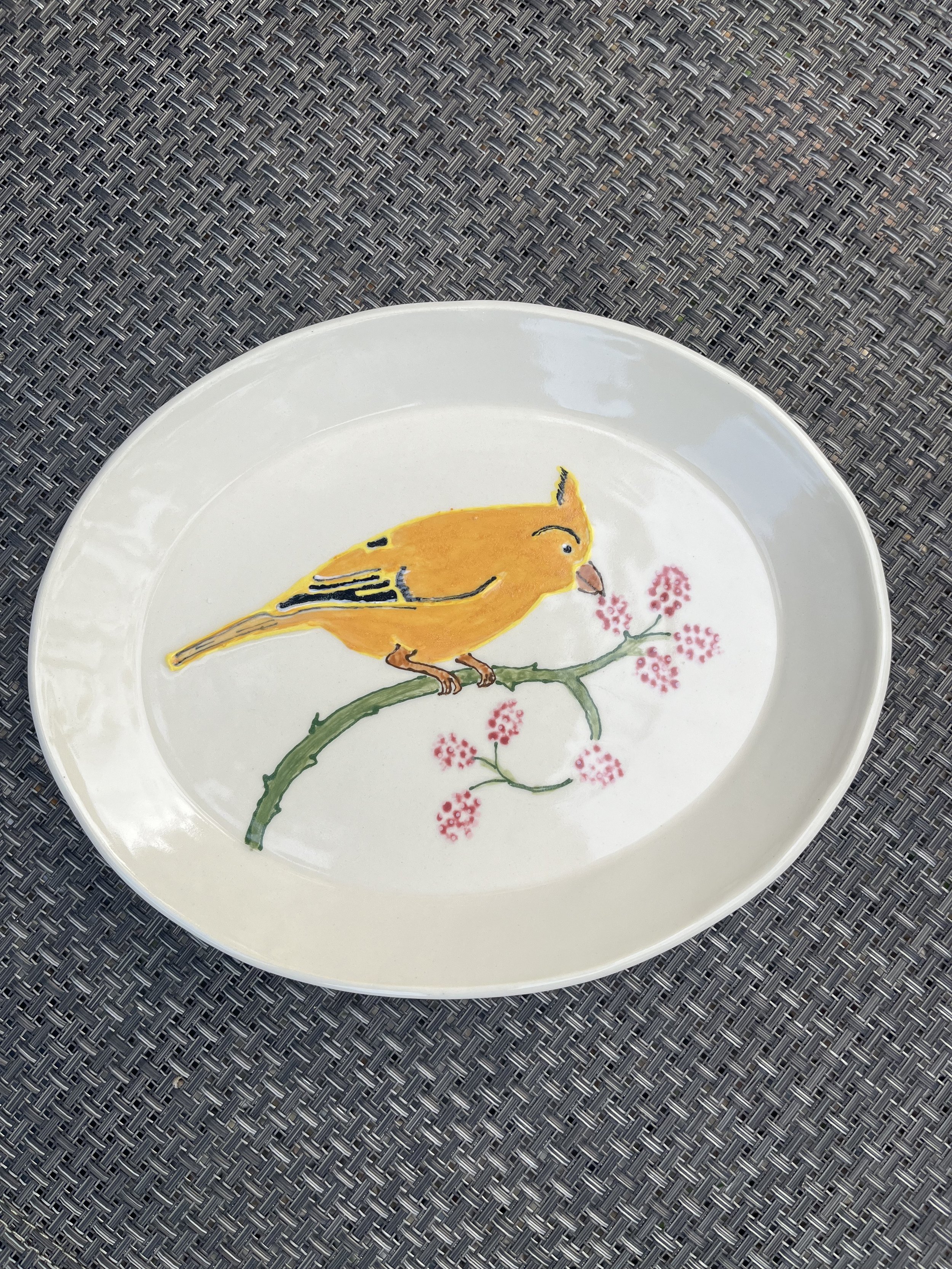 Oval plate, yellow bird with raspberries