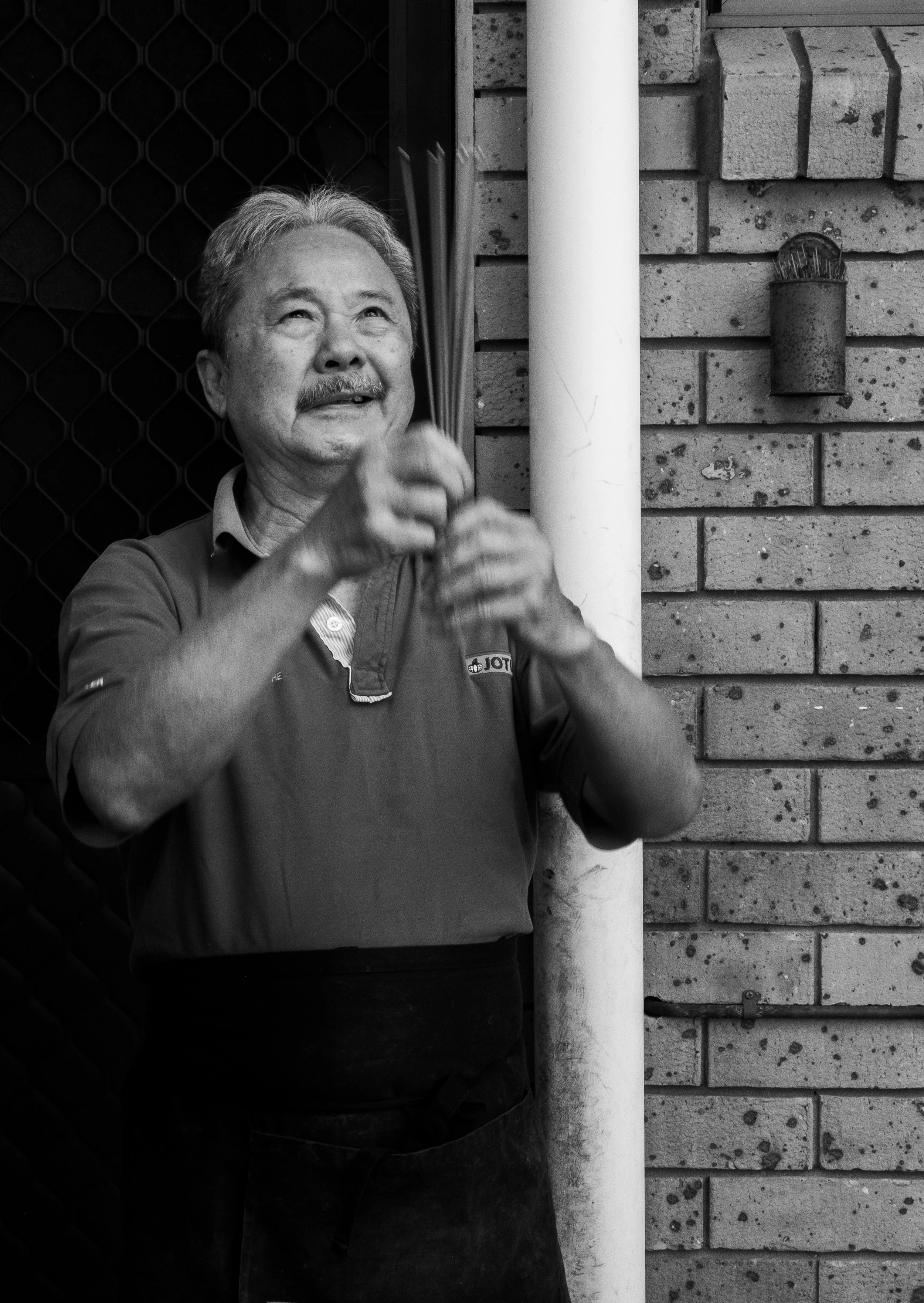 Francis is captured preparing and lighting incense to sit beside the back door of the kitchen, a ritual the couple have been doing fortnightly for 30 years. They tell me this is what has protected and provided for them.