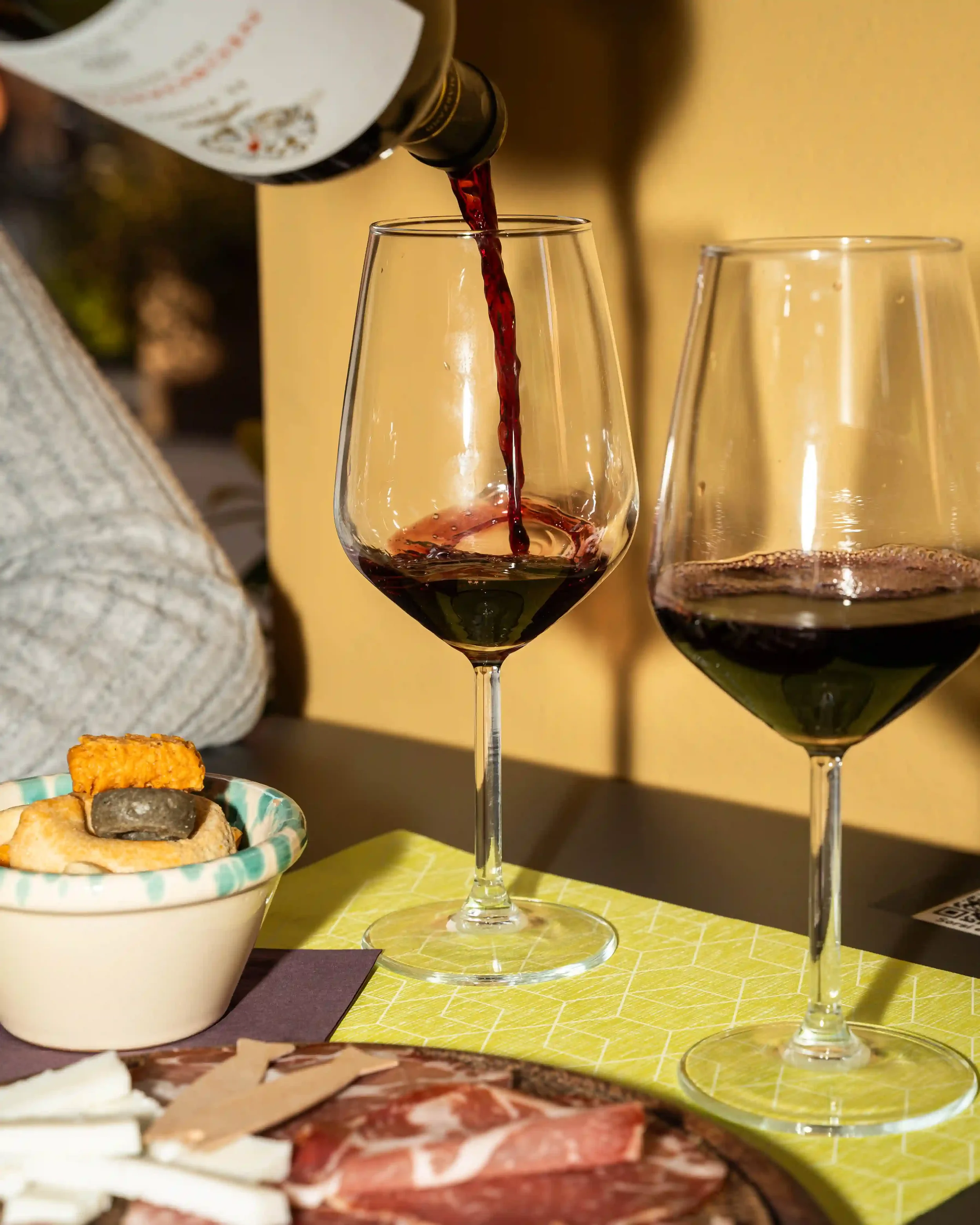Aperitivo con calice di vino rosso, taralli e tagliere di salumi e formaggi