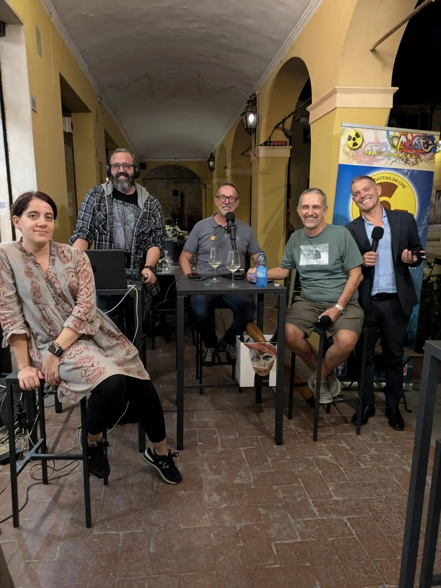 Boomers 3.0 è una trasmissione webradio  trasmessa da Radioattiva Nonantola. Nella foto gli speakers e lo staff della trasmissione sotto al portico di via Roma davanti a Sorsi e Morsi. Foto settembre 2025