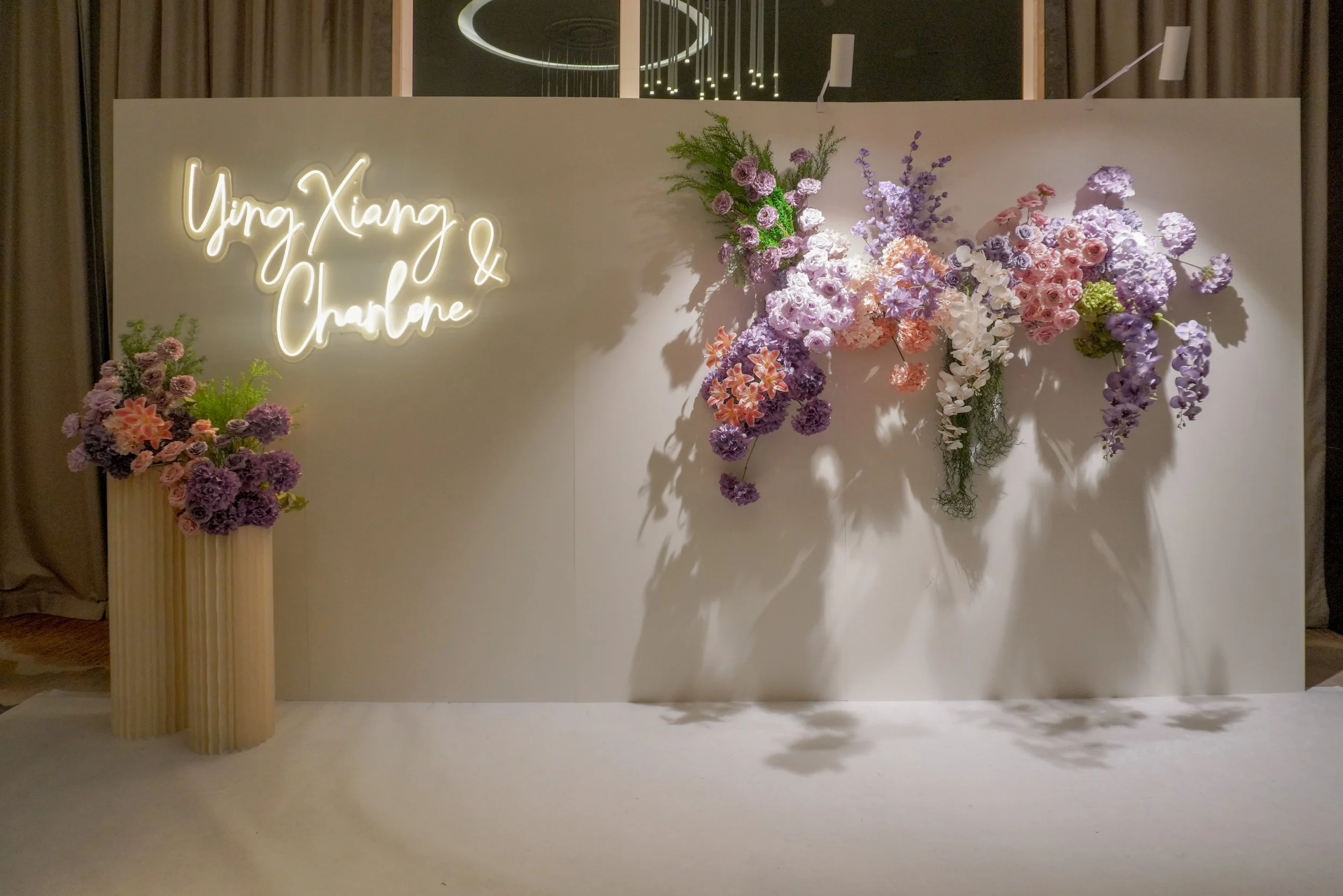 Wedding backdrop with purple and pink faux floral arrangements and LED Signage for a wedding ceremony and photobooth in Singapore at One farrer hotel 