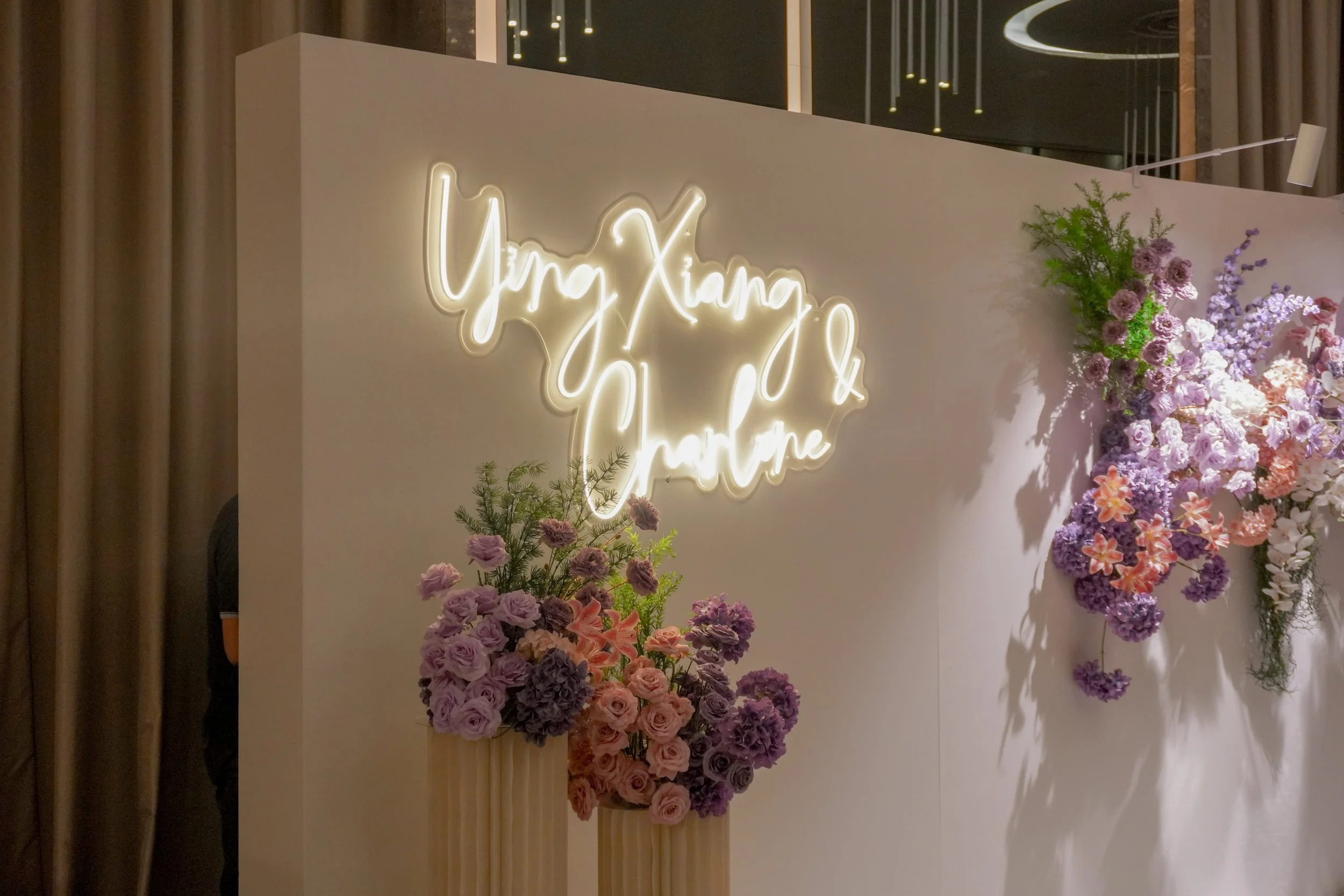 Wedding backdrop with purple and pink faux floral arrangements and LED Signage for a wedding ceremony and photobooth in Singapore at One farrer hotel 