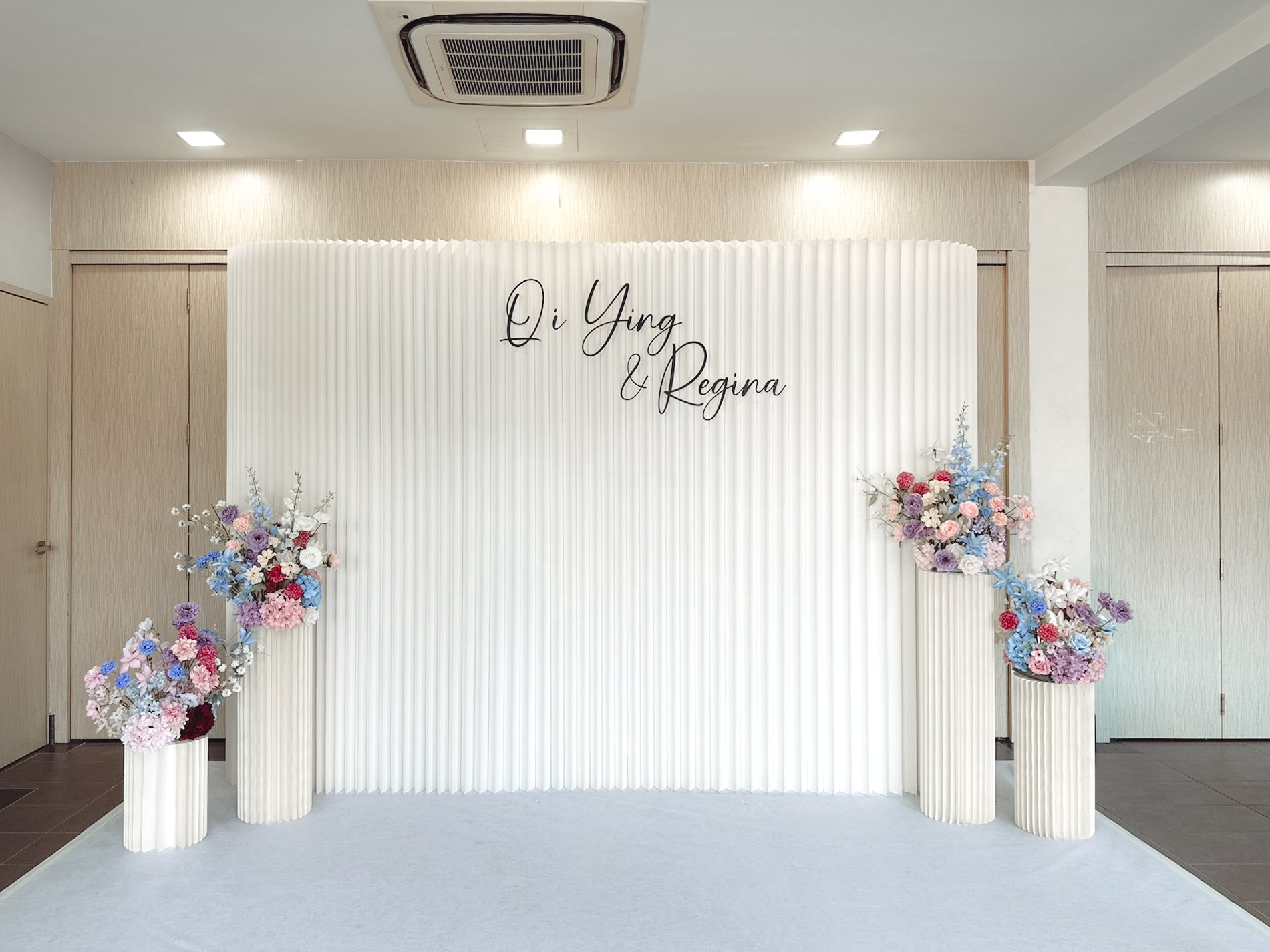 Pleated backdrop with customised faux florals for a church wedding reception and photobooth