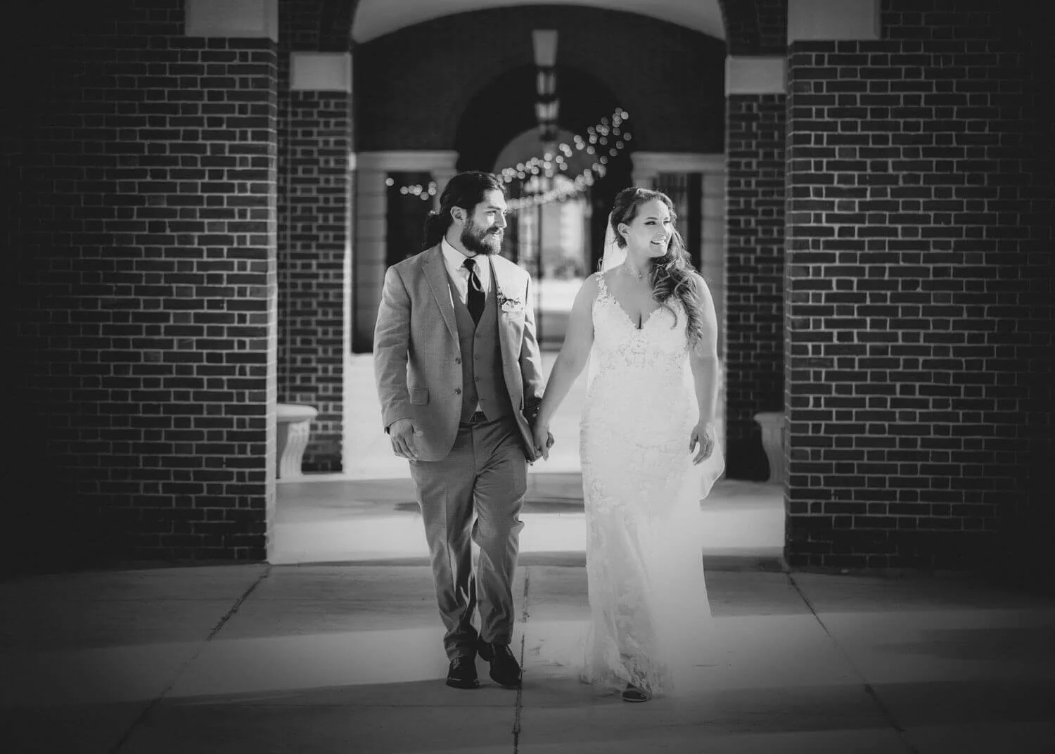 black and white wedding photography of bride and groom walking