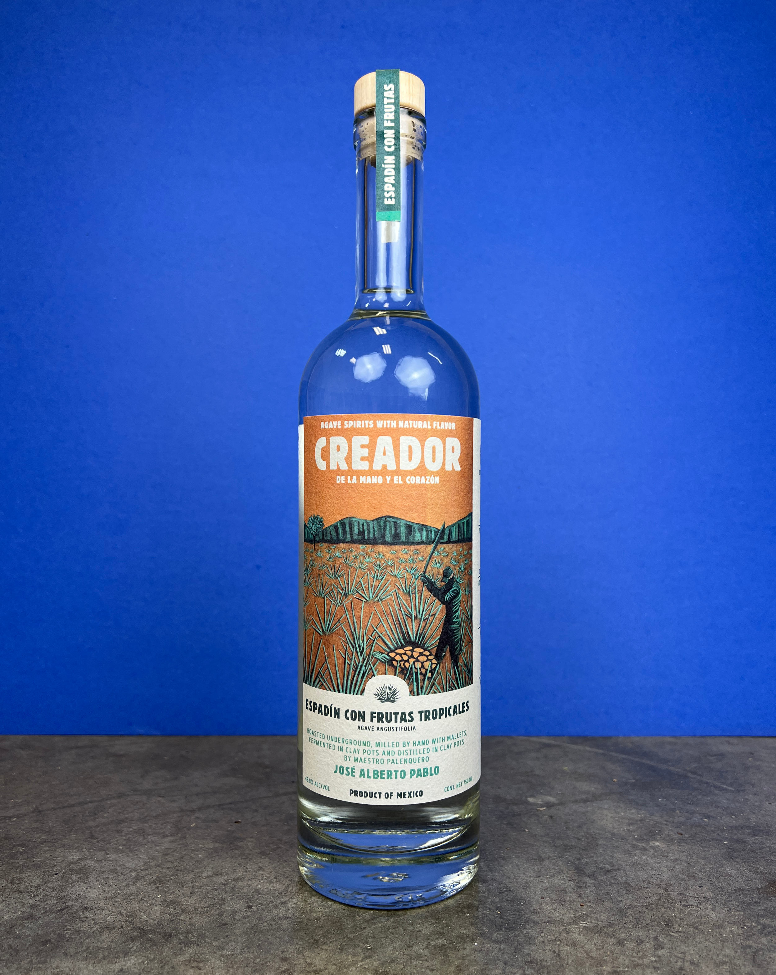 A bottle of Creador Espadin con Frutas agave spirit with a colorful label