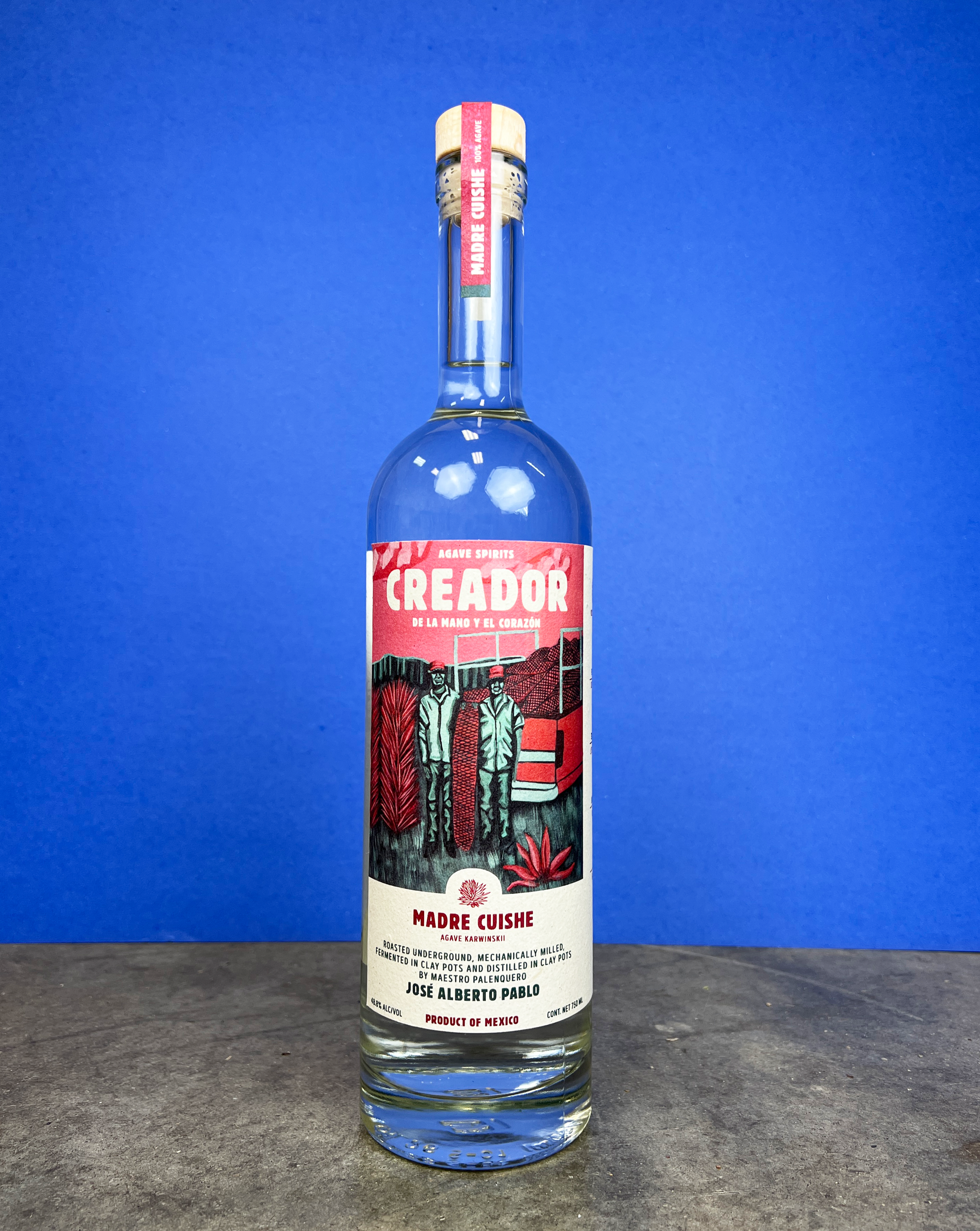 A clear glass bottle of Creador Madre Cuish agave spirit