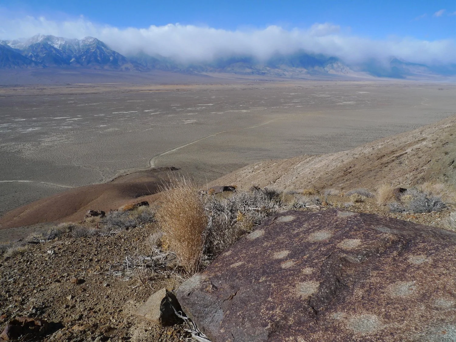 Cup marks on a ridge / storm hang over the Sierra / a favorite trail
