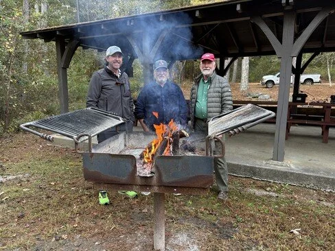 Jesse N4JAH, Phillip W4PHC, and Claude AC4SH standing in front of a cooking grill witing for the fire to die down to coals.