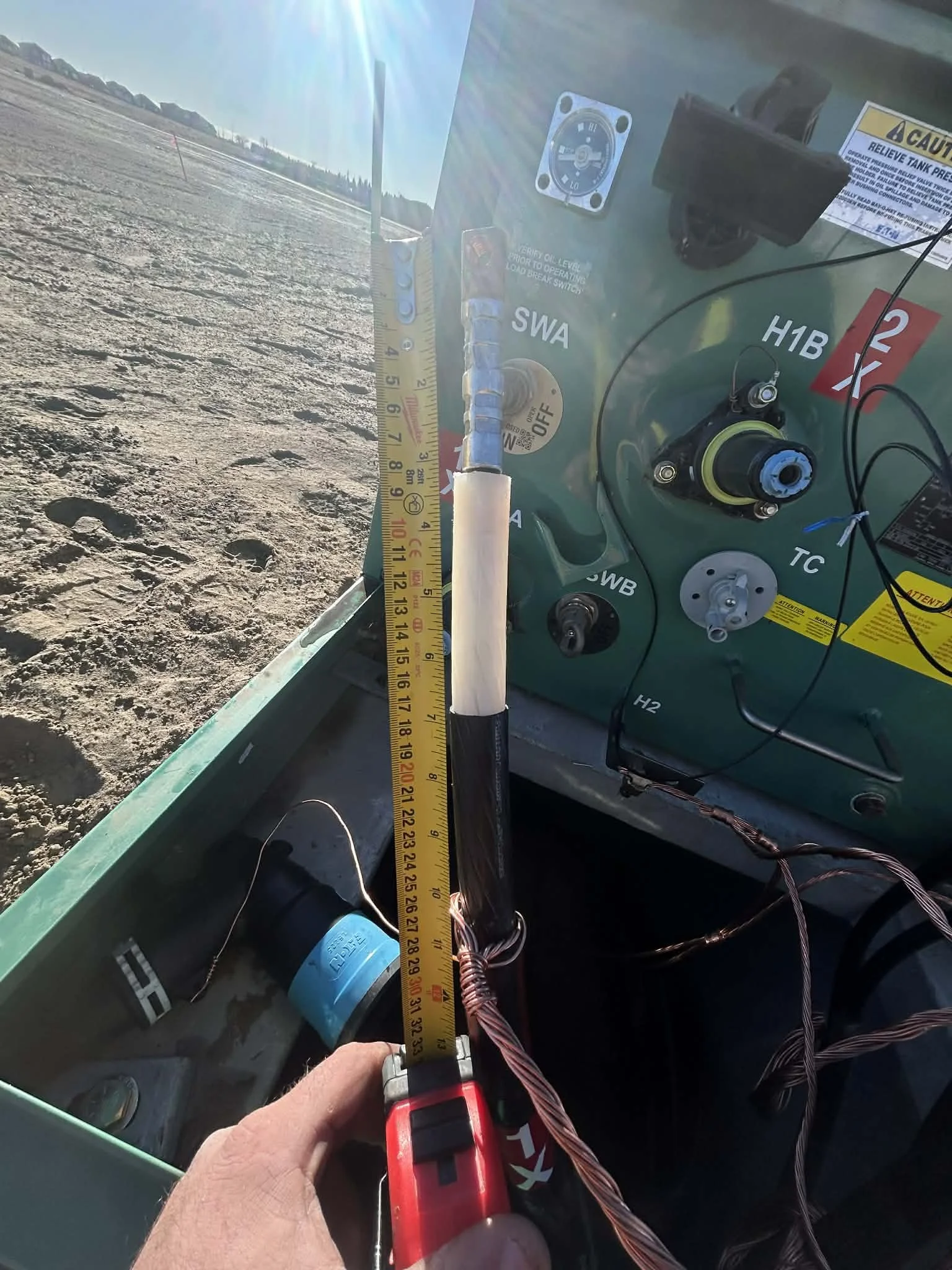Close-up of a measurement being taken inside a green aircraft cockpit, with a ruler extending from the floor to above the instrument panel, showing a measurement of approximately 19 inches.