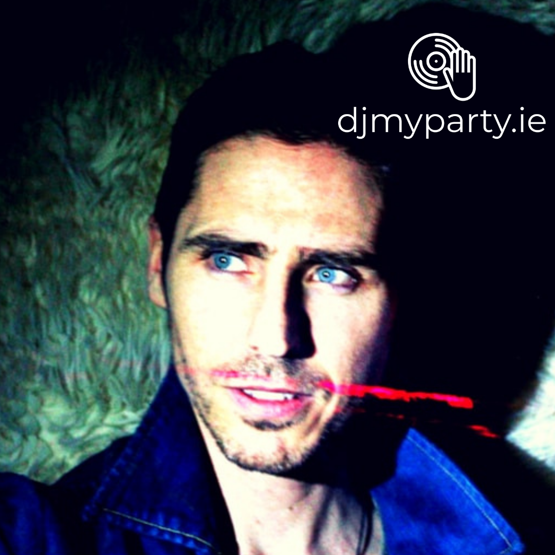 Man with blue eyes and stubble, wearing a denim jacket, looking off-camera, with "djmyparty.ie" and a logo in the top right corner.