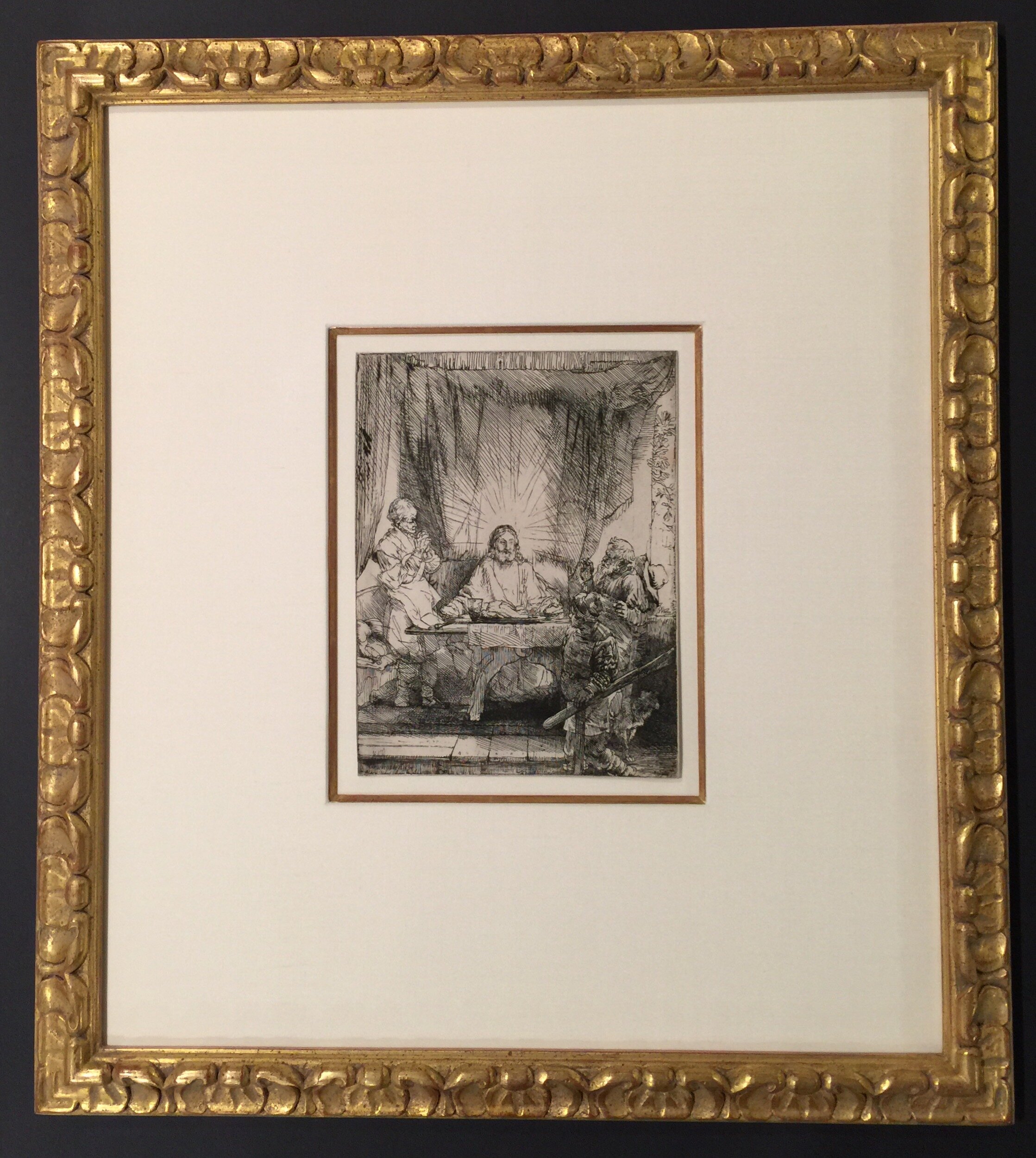 Antique print in a carved gold frame and a mat with a gold filet. 