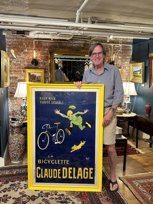 Dave presenting a large vintage print in a bright yellow glossy frame.