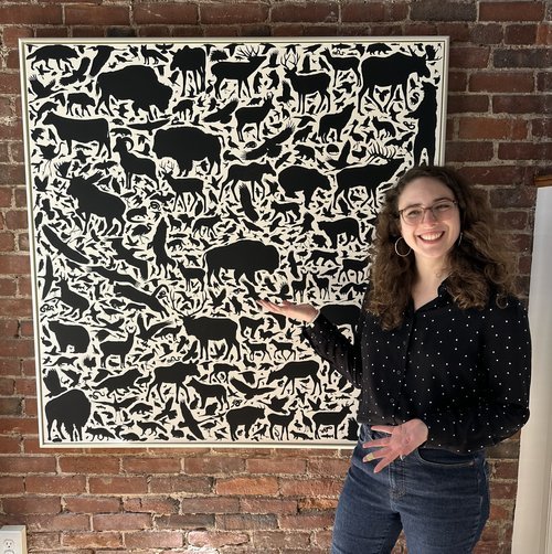 Tyler presenting a large canvas in a float frame, custom painted to match the artwork.