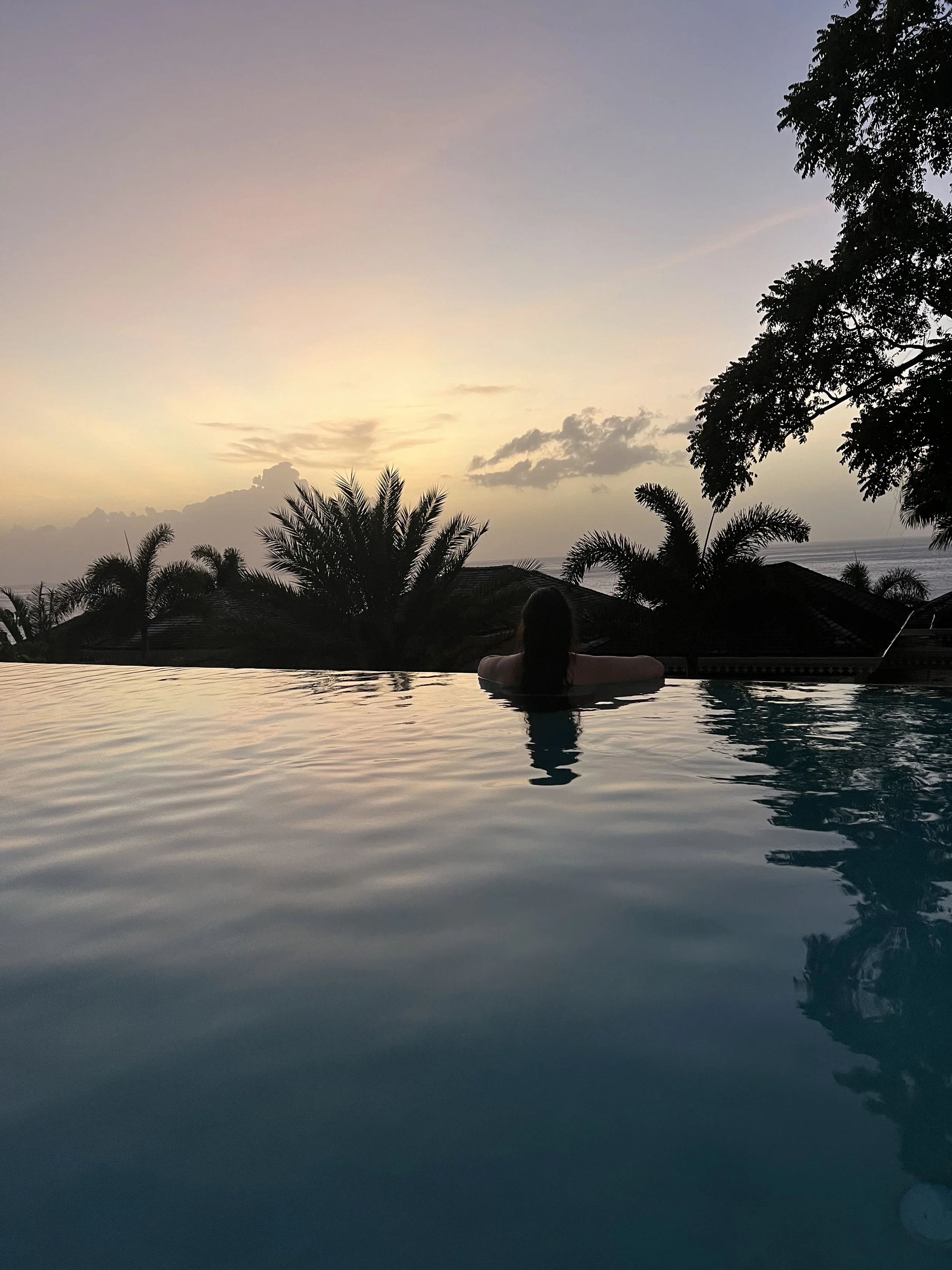 Woman in plunge pool in four bedroom villa during sunset, overlooking ocean