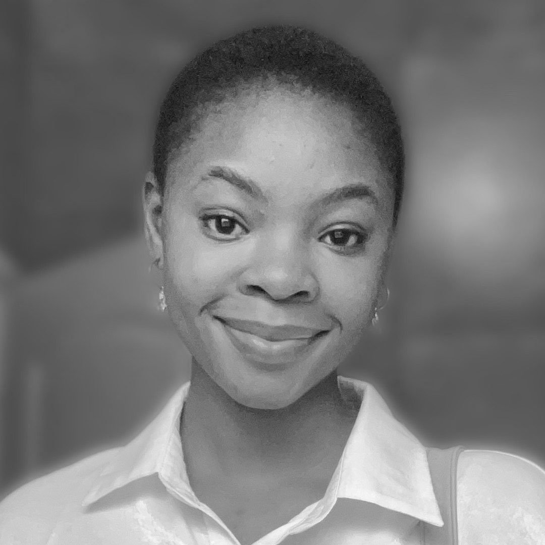 Black and white portrait of a smiling woman with short hair, wearing a collared shirt and earrings.