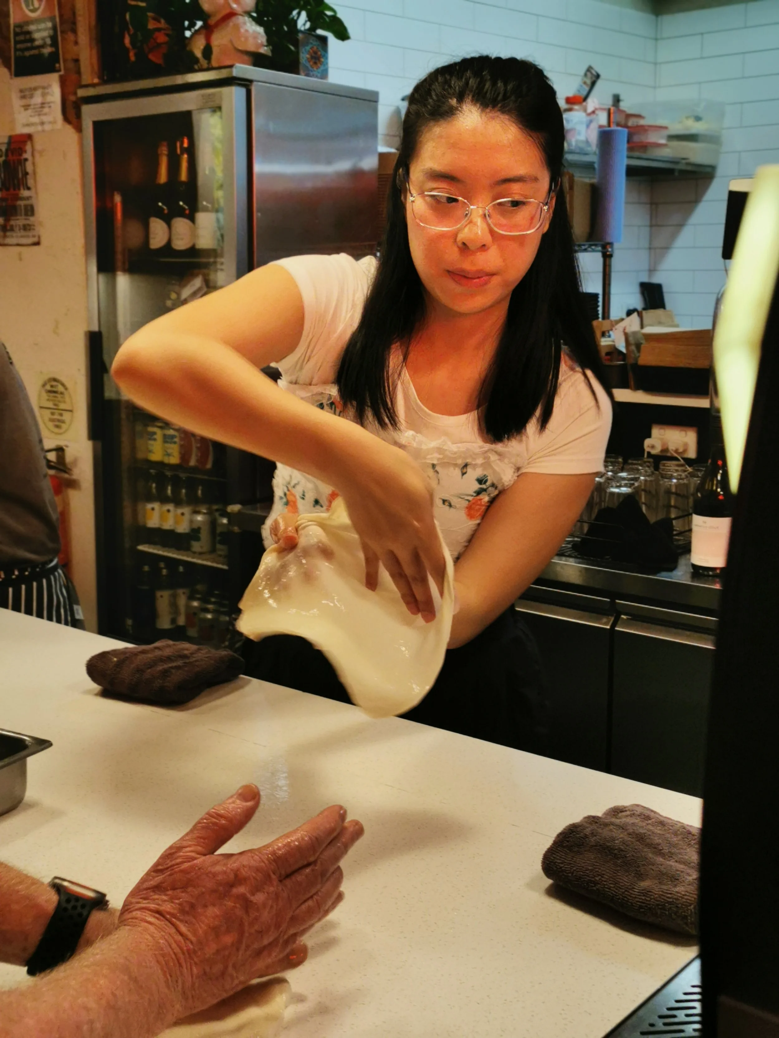 Guest flipping roti in the air at Kafe Kooks Roti Masterclass