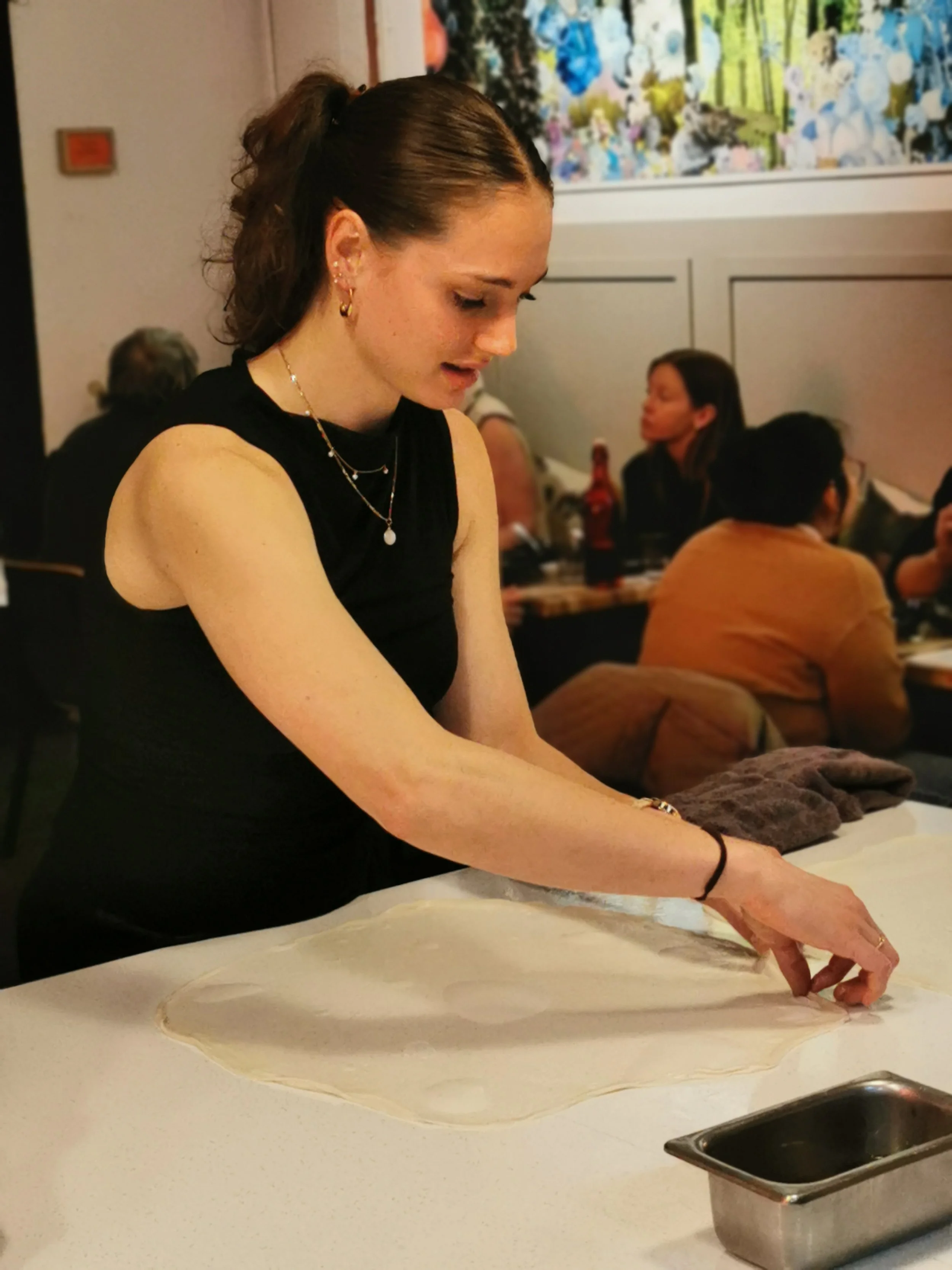 Guest learning the roti stretch technique at Kafe Kooks Thursday class