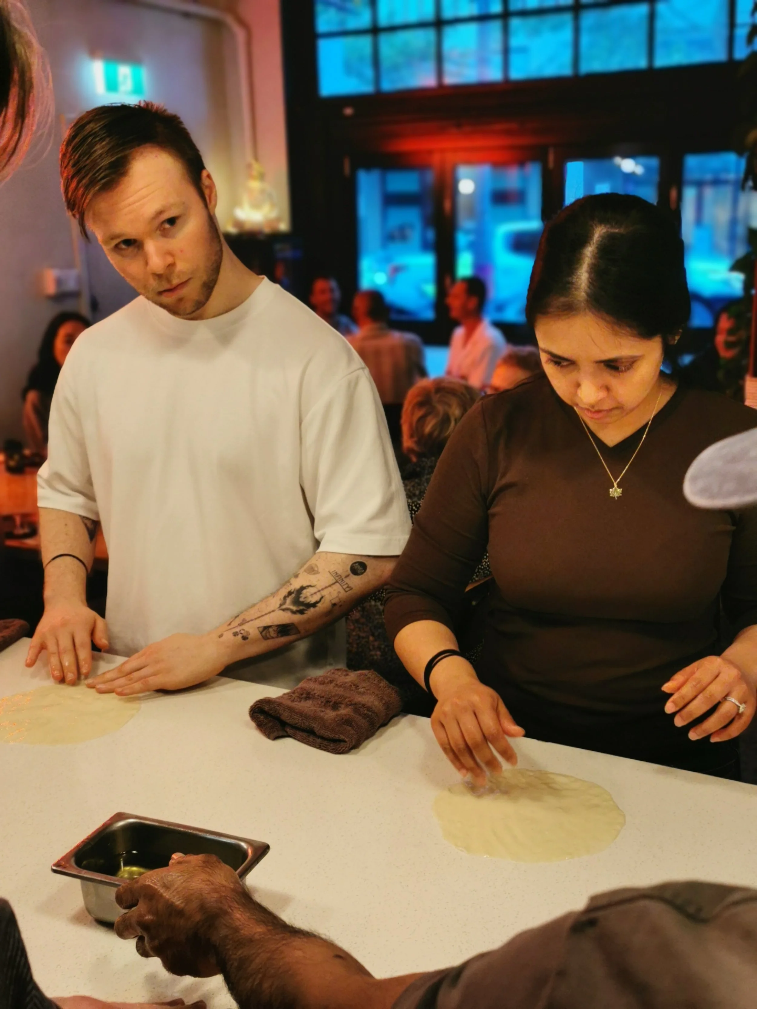 Guest learning the roti stretch technique at Kafe Kooks Thursday class